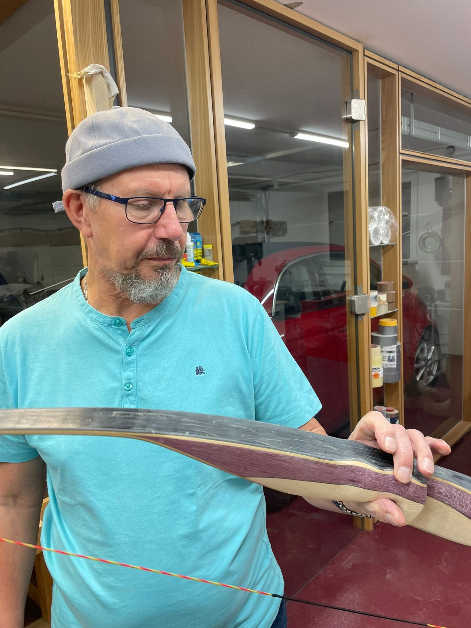 Ein Mann in einem blauen Hemd hält ein Stück Holz