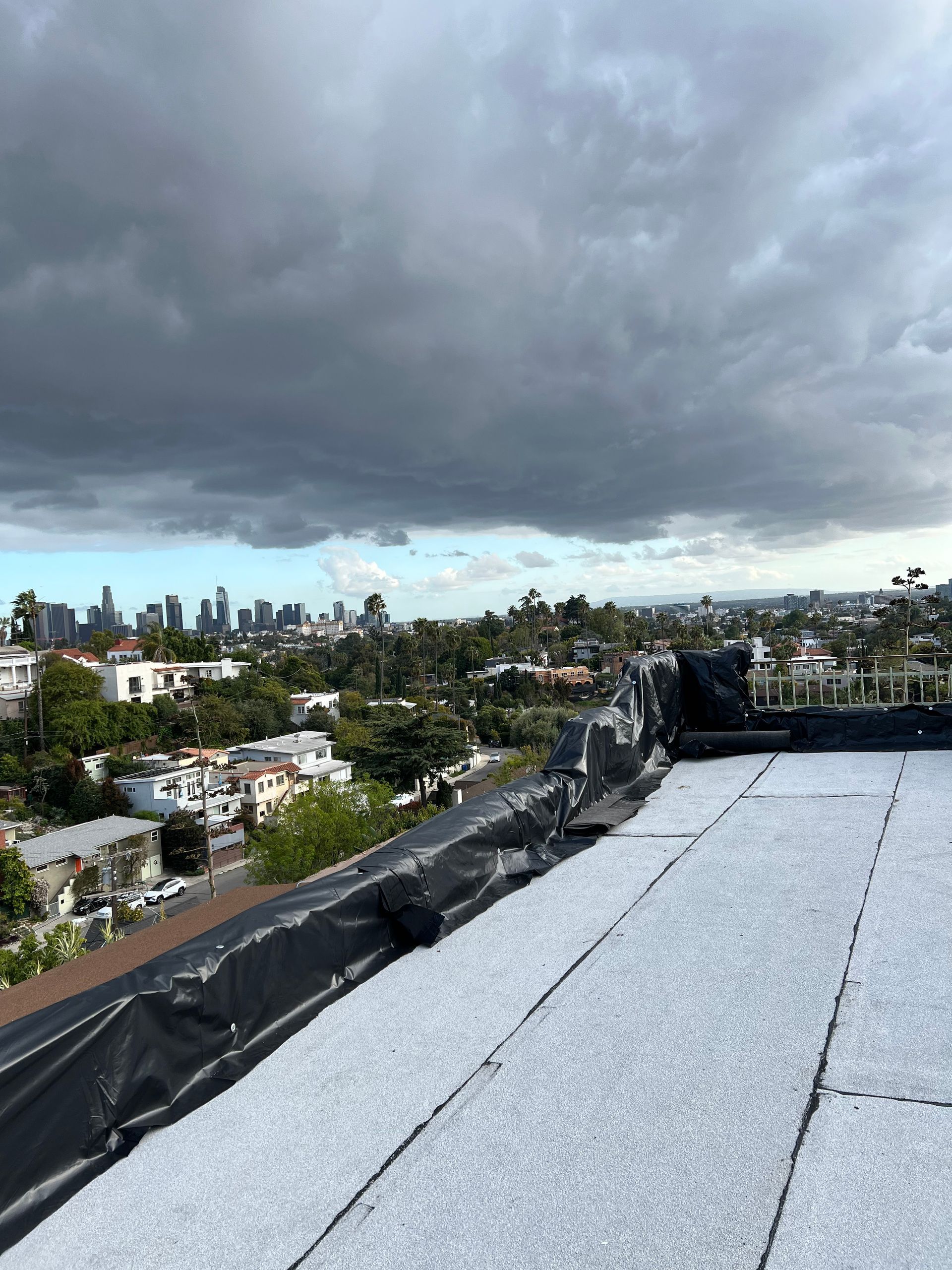 Um telhado com vista para uma cidade e um céu nublado.