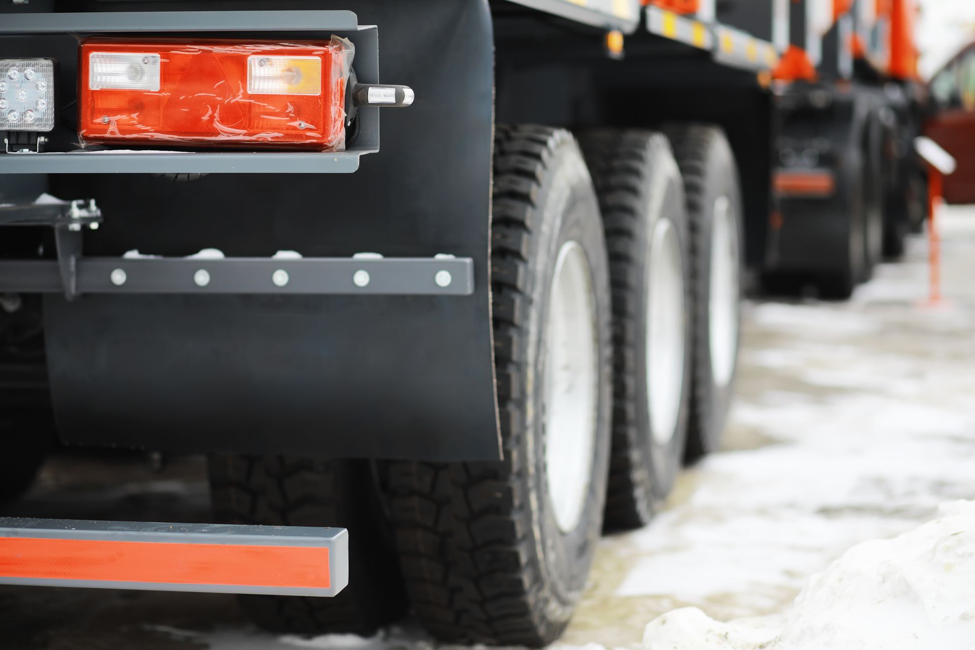 Black truck rear with wheels on snow, red lights. Black truck rear with wheels on snow, red lights.