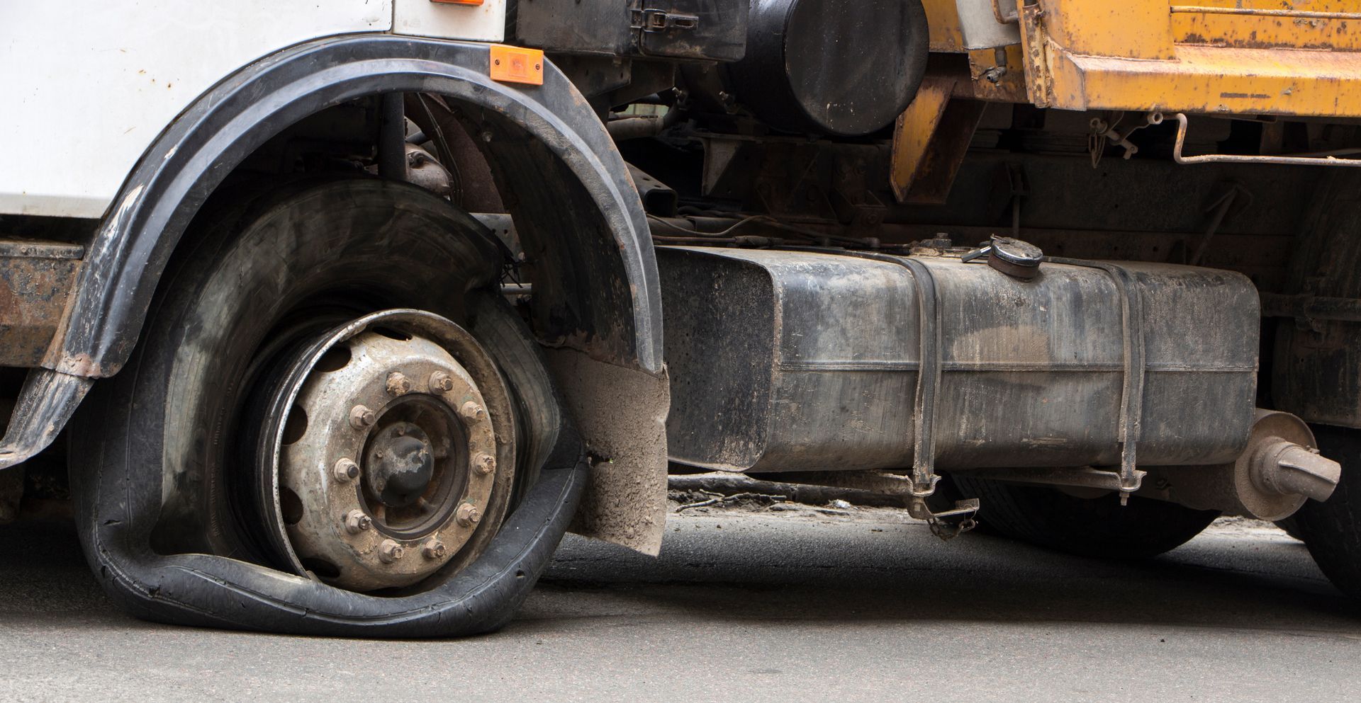 Flat tire on a work truck; black, deflated tire. Flat tire on a work truck; black, deflated tire.