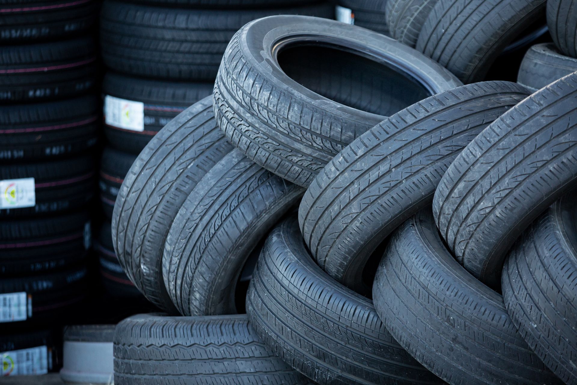 Pile of used black tires in a storage area.