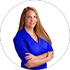 Woman in a blue blouse smiling with arms crossed on a white background