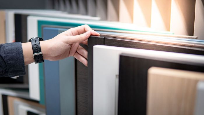 male hand choosing cabinet panel materials