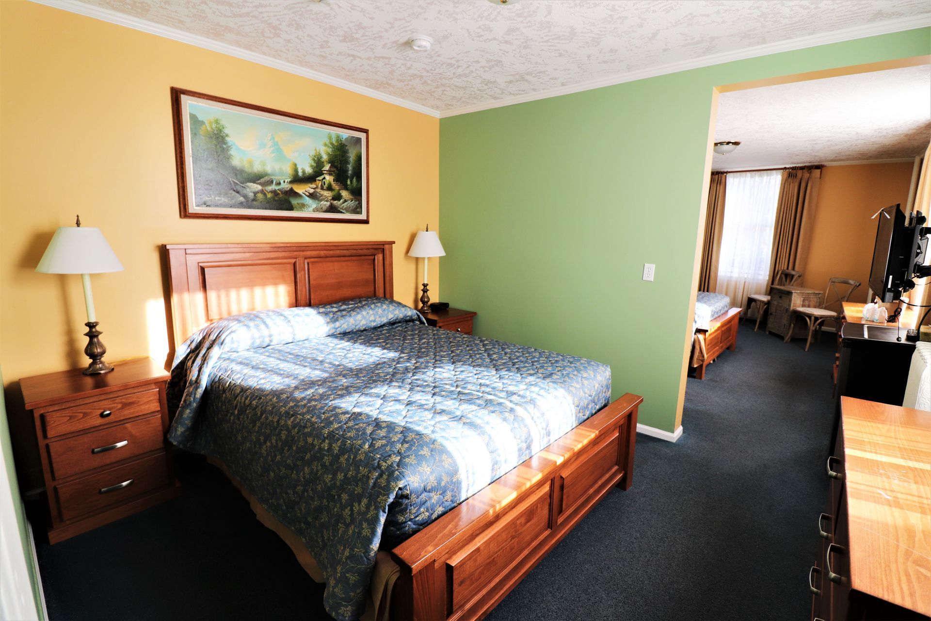 A hotel room with a large bed and a painting on the wall