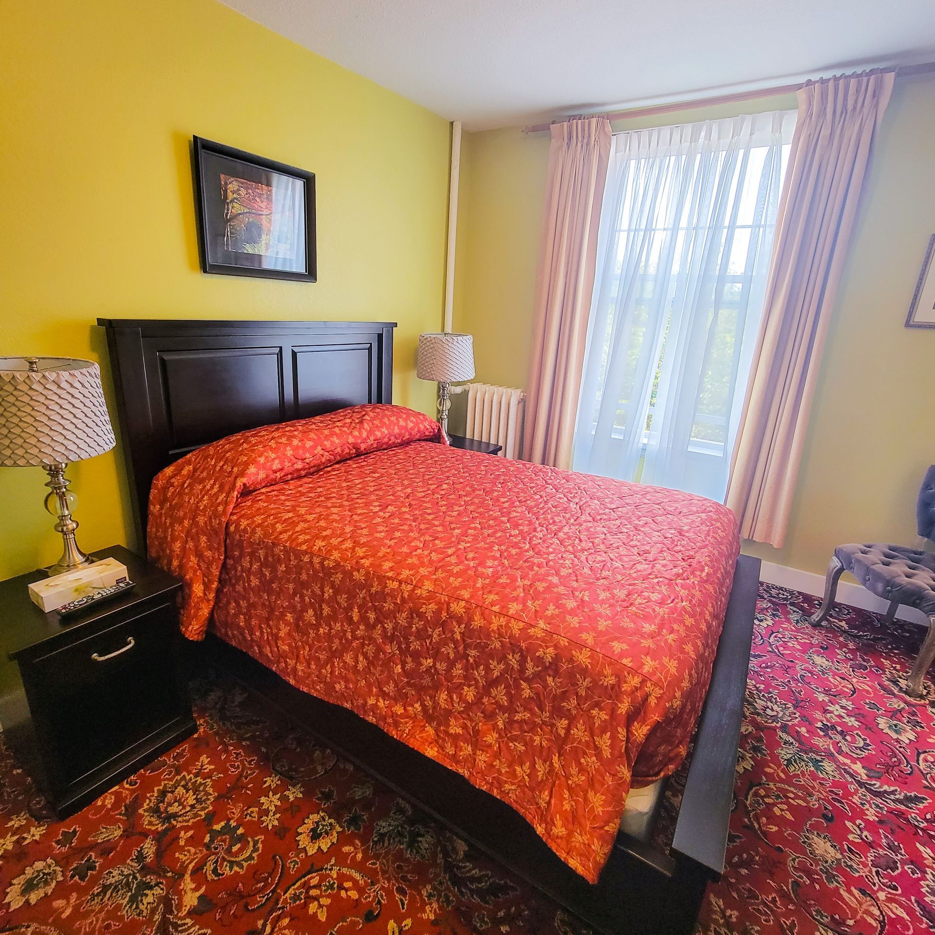 A bedroom with a large bed and two lamps