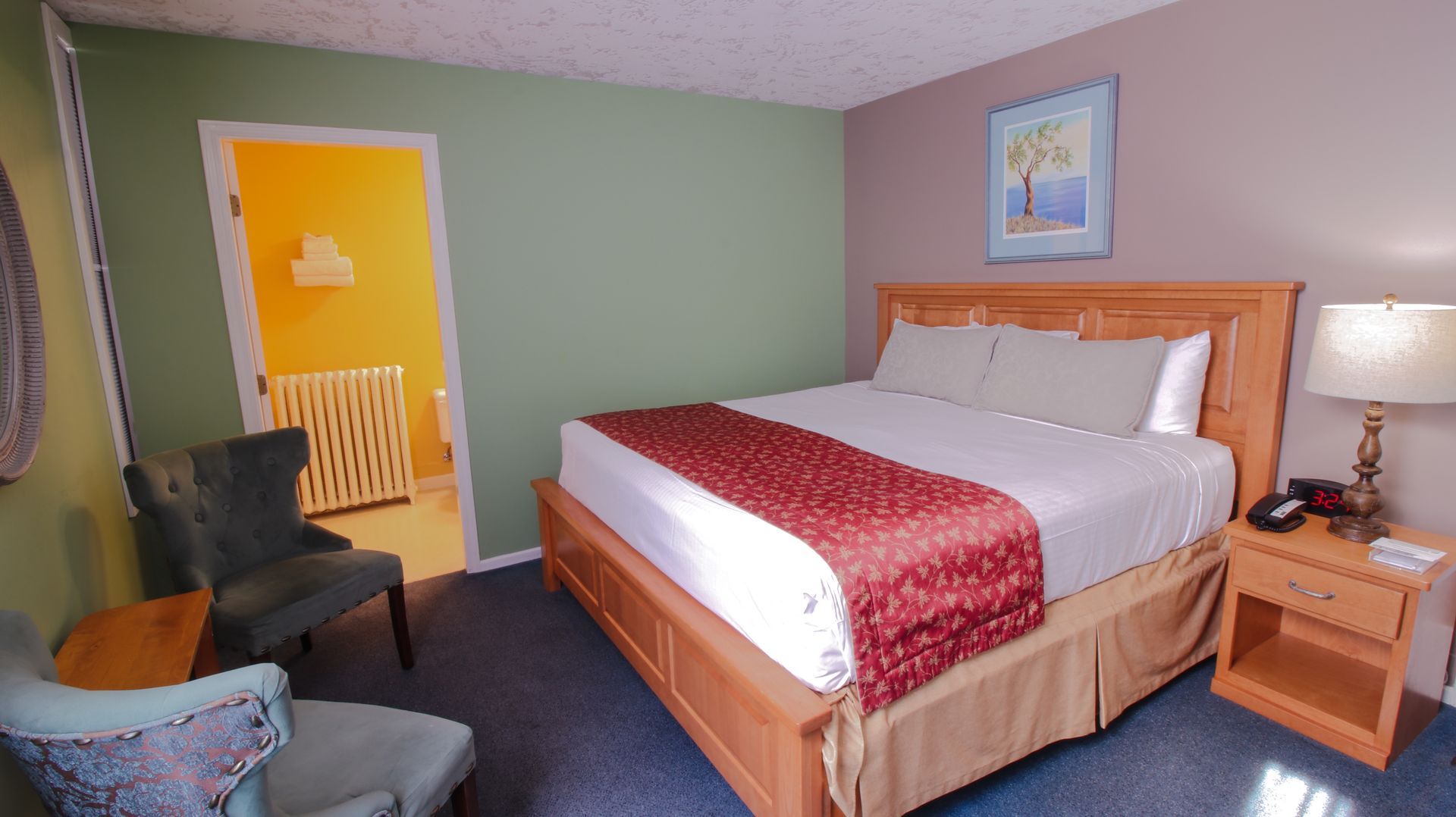 A hotel room with a king size bed and a chair