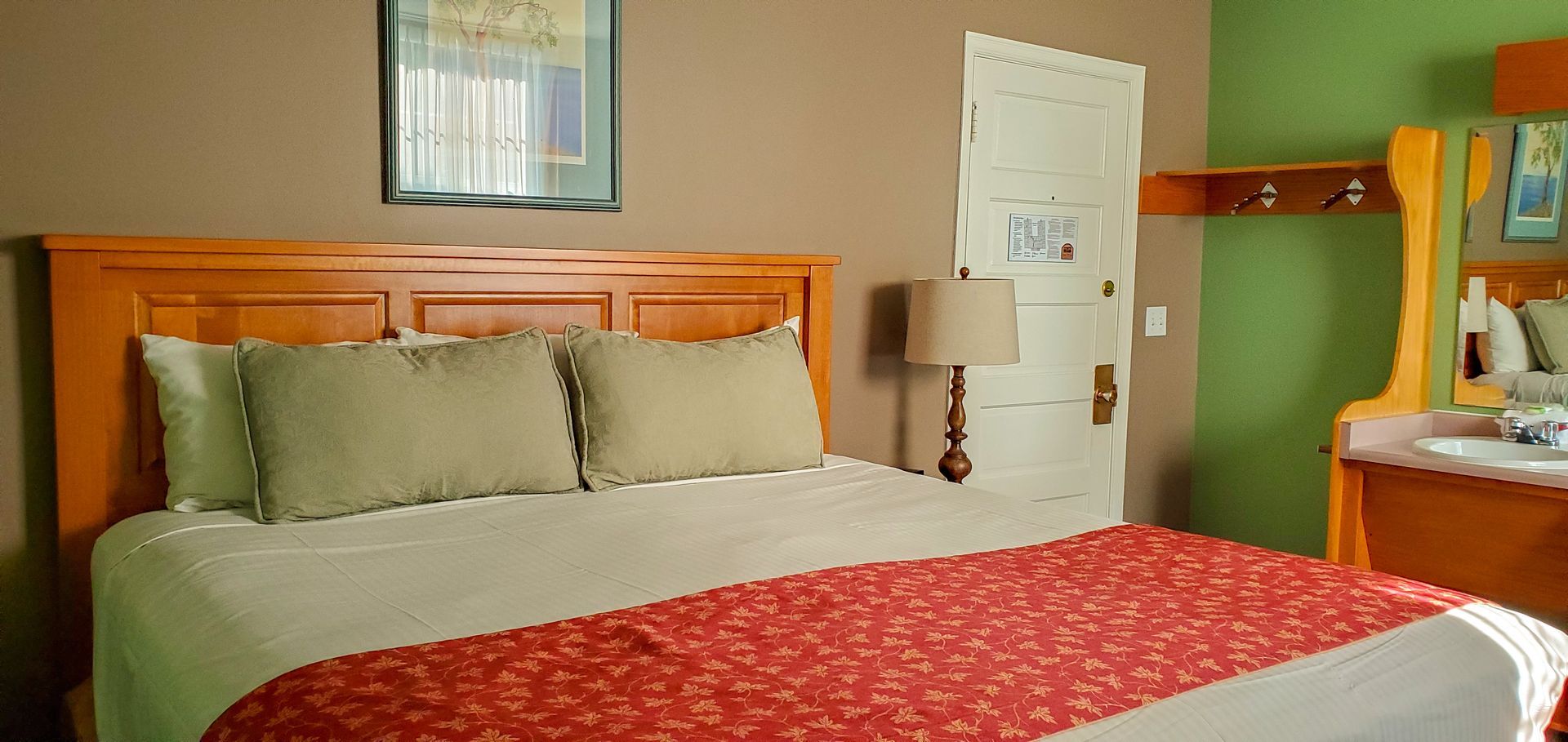 A hotel room with a king size bed and a sink.