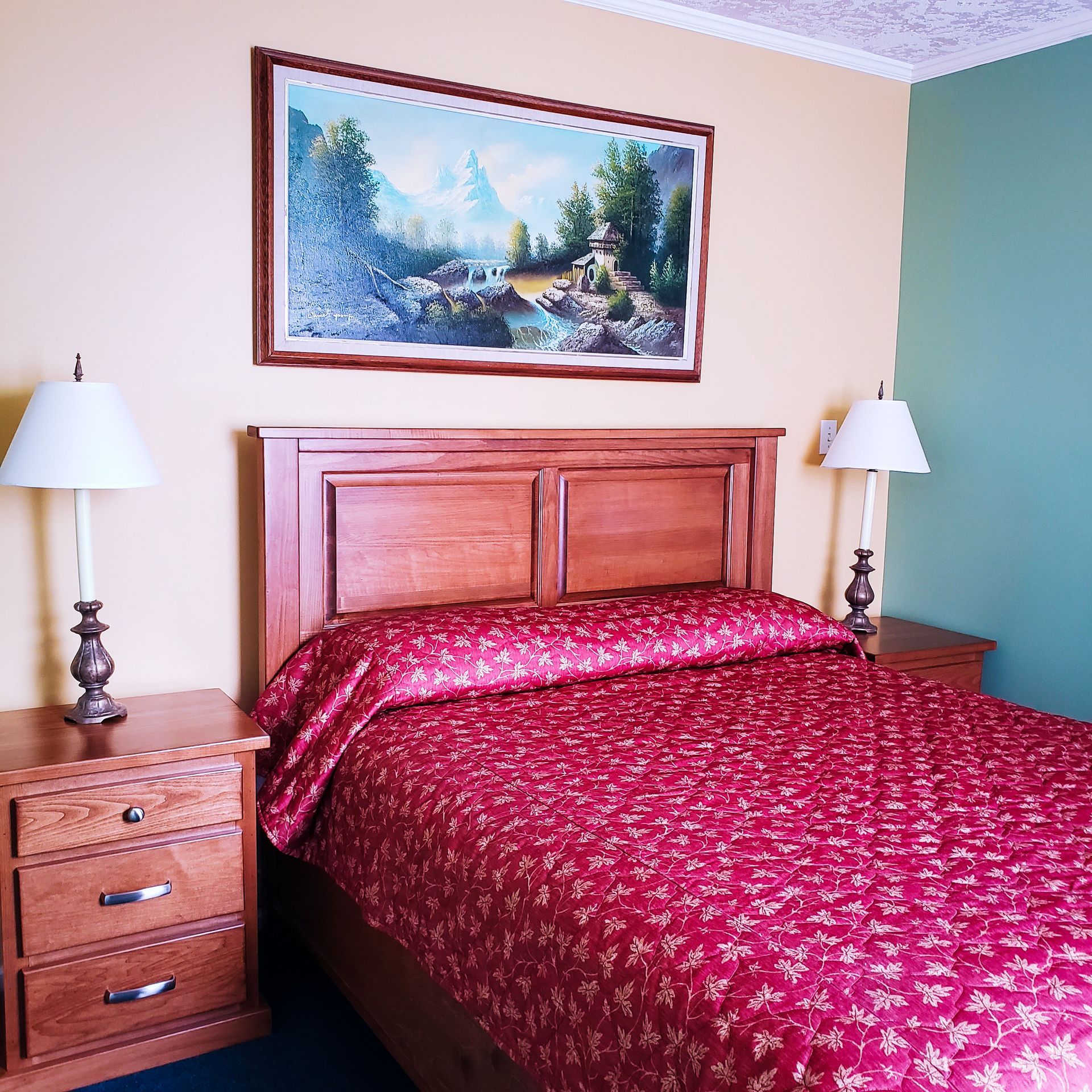 A bedroom with a bed and a painting on the wall above it
