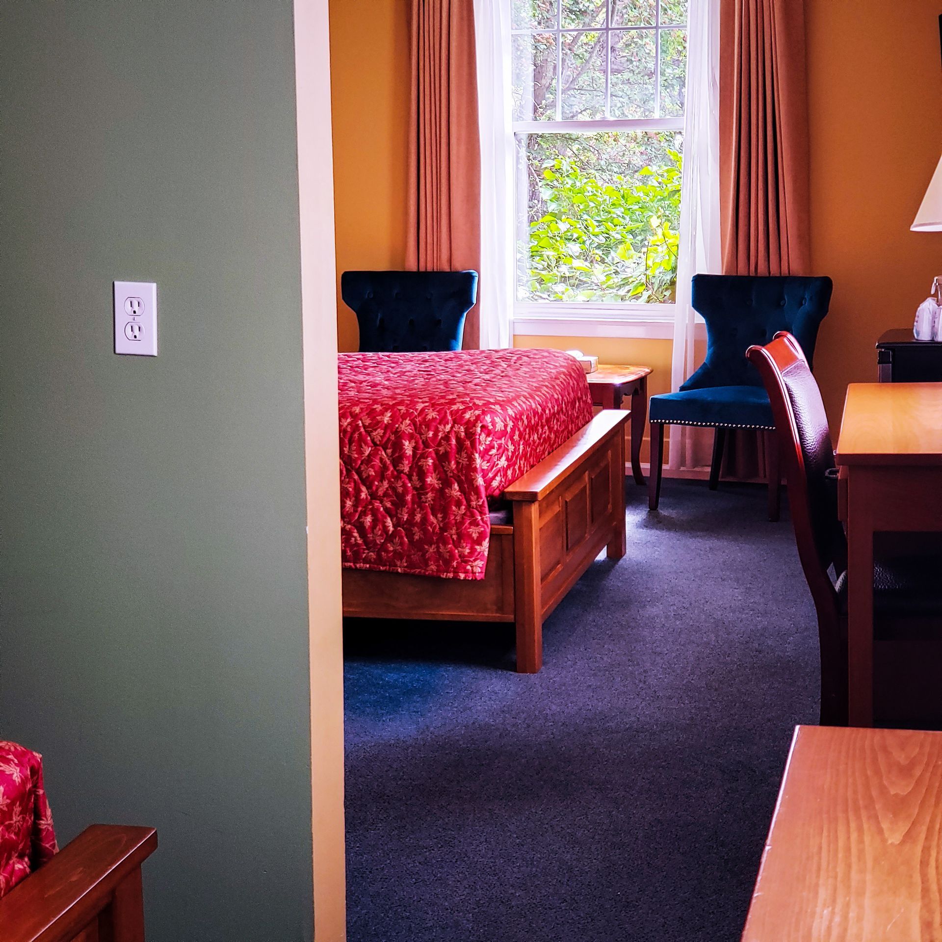 A hotel room with a bed a desk and chairs