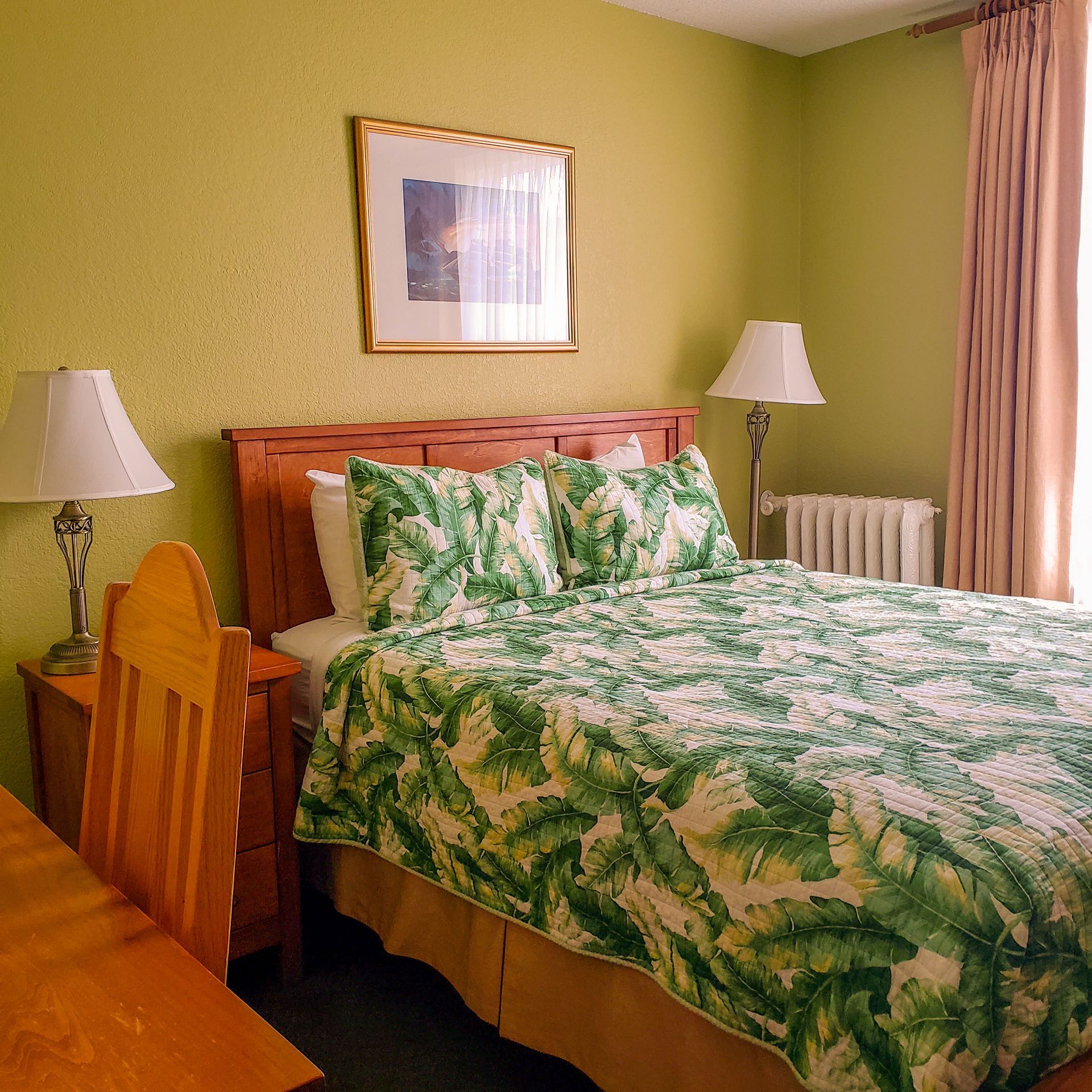 A hotel room with a bed and two lamps