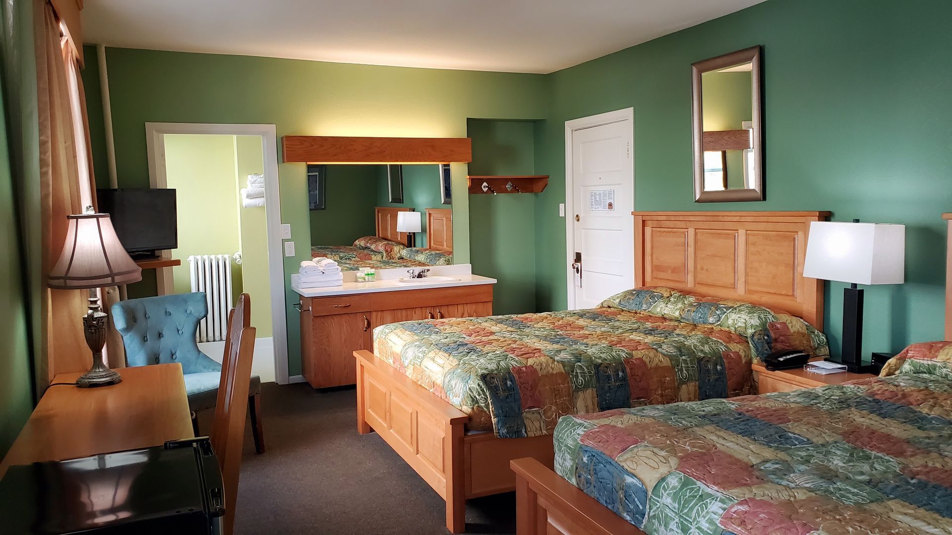 A hotel room with two beds and a mirror