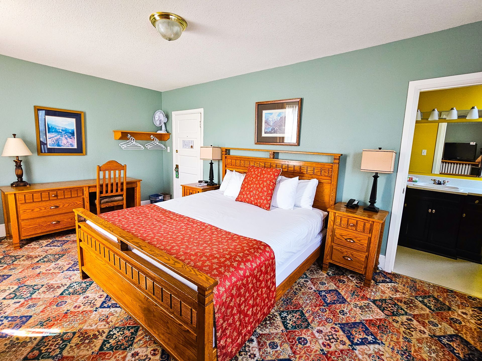 A hotel room with a king size bed and a desk