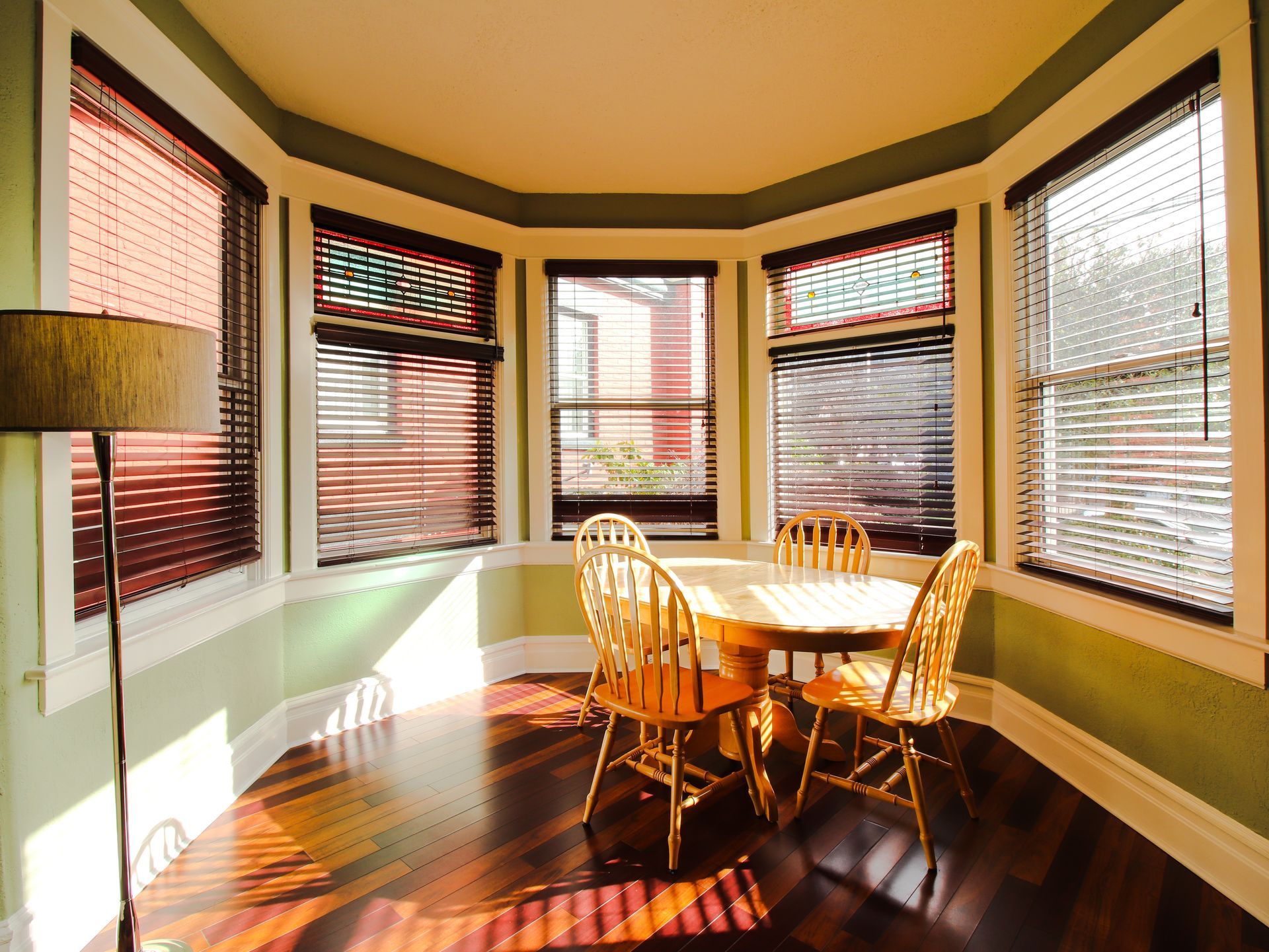 A dining room with a table and chairs and lots of windows