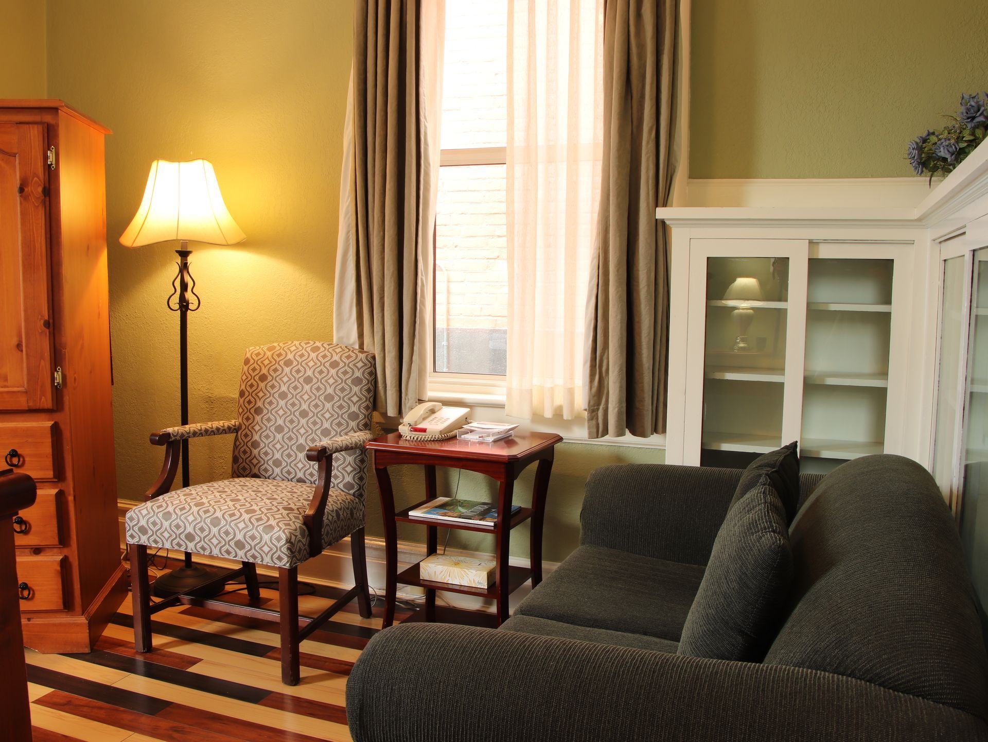 A living room with a couch a chair and a lamp