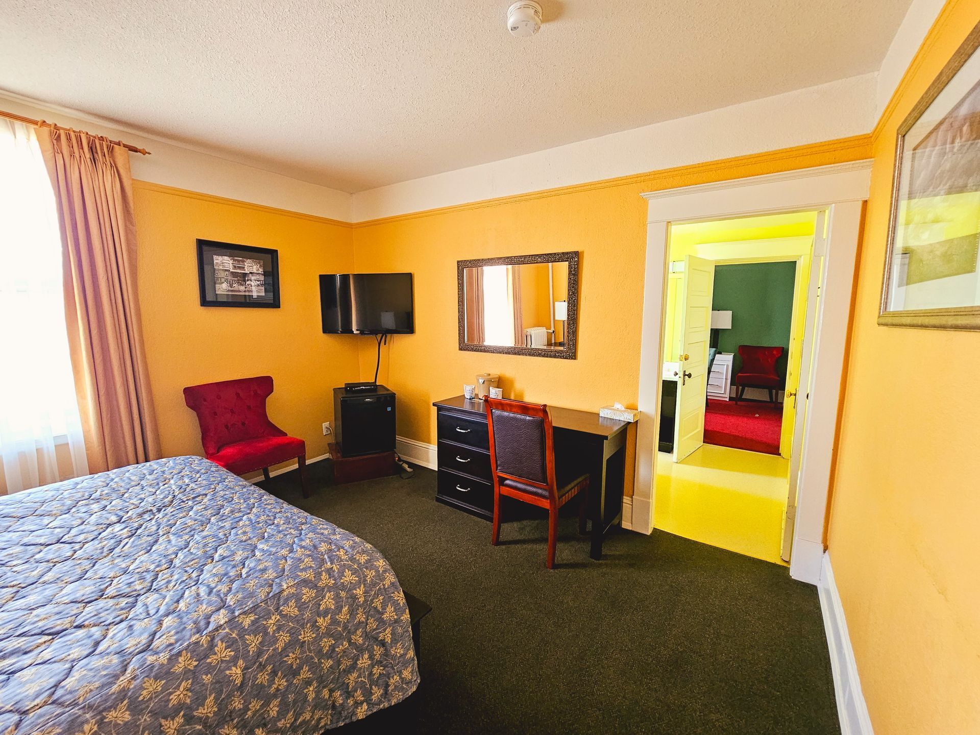 A hotel room with a bed , desk , chair and television