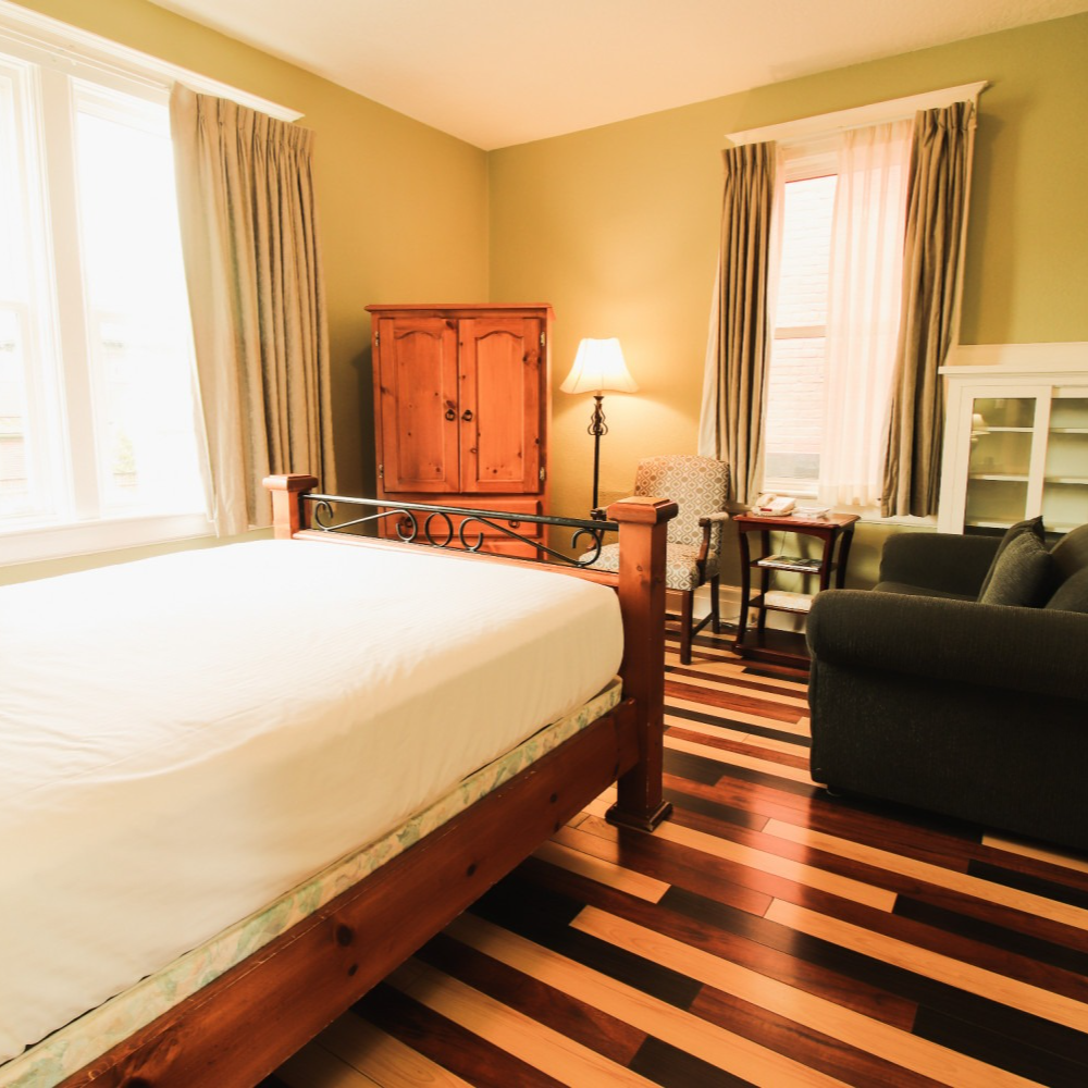 A bedroom with a large bed and a striped floor