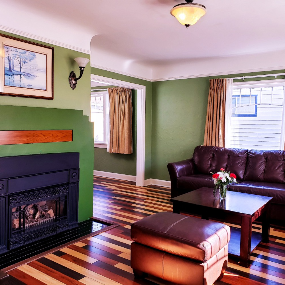 A living room with green walls and a fireplace