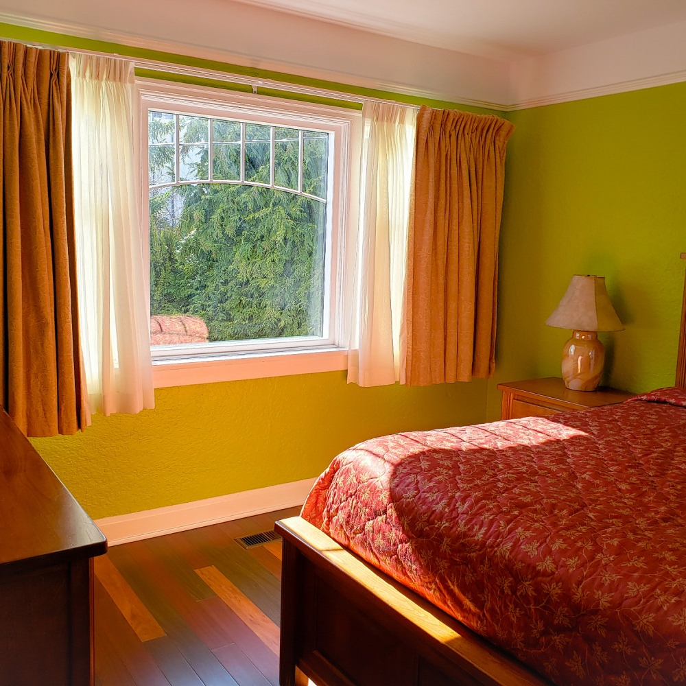 A bedroom with green walls and a red bed