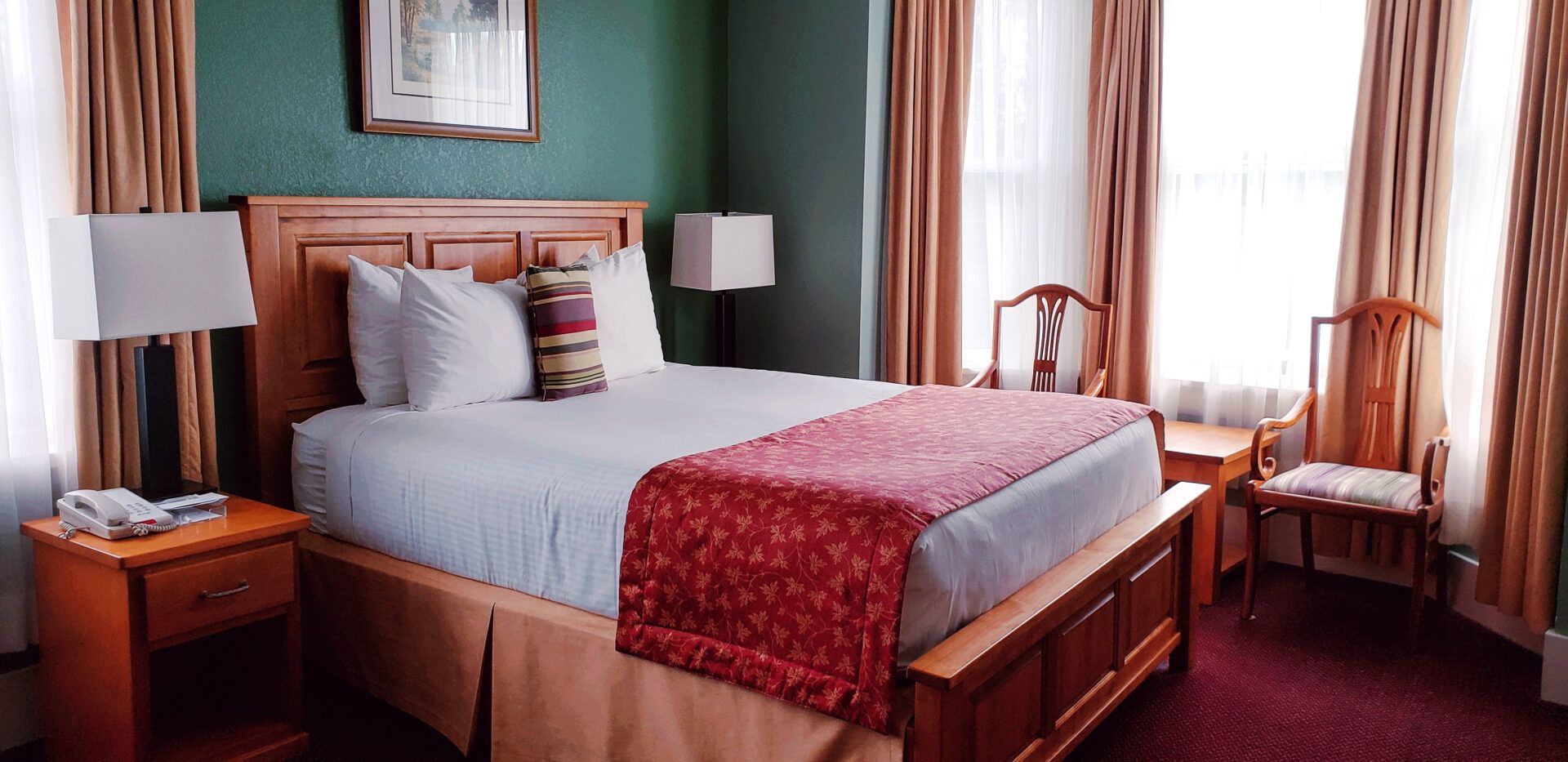 A hotel room with a king size bed and a chair