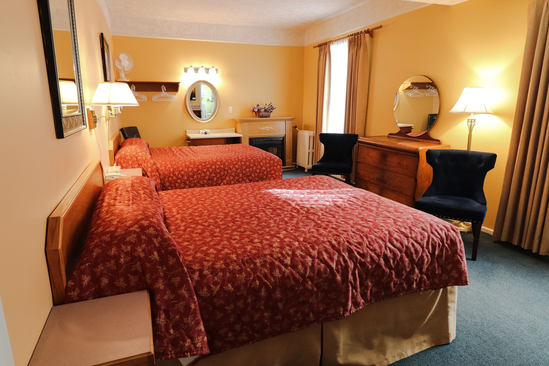 A hotel room with two beds and a dresser