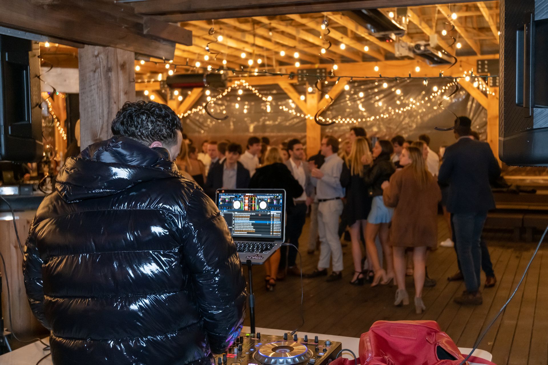 A dj is playing music to a crowd of people at a party.