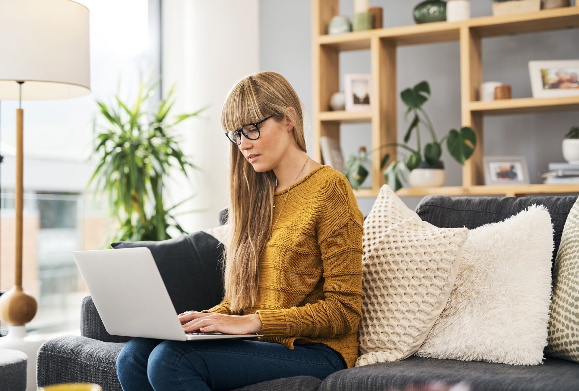 Woman sitting at a table looking at her laptop