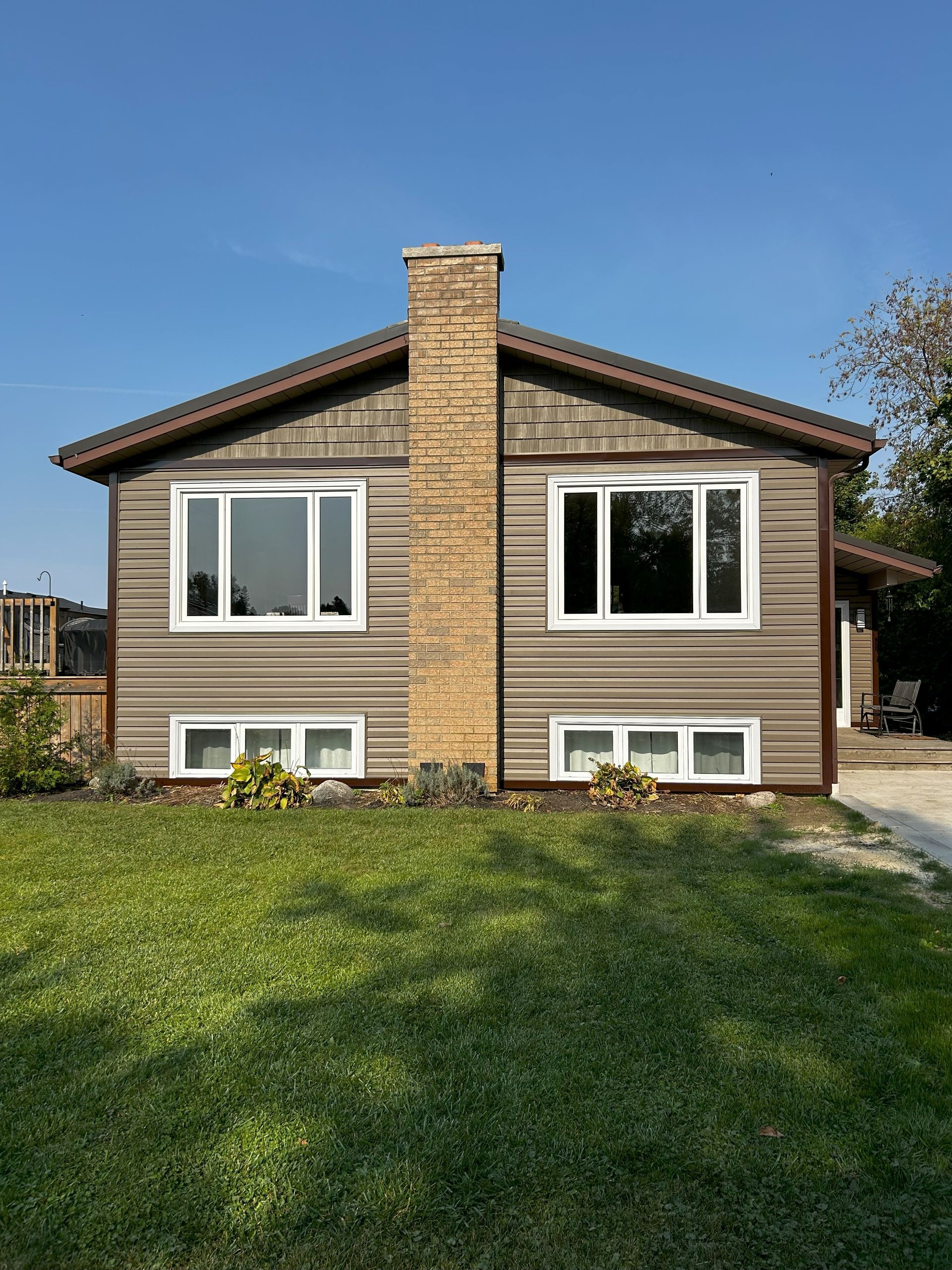 A house with a brick chimney and a lot of windows
