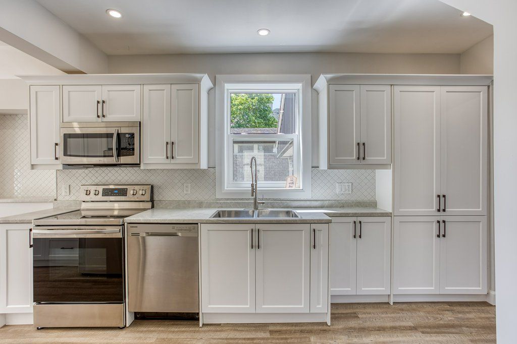 A kitchen with white cabinets and stainless steel appliances.