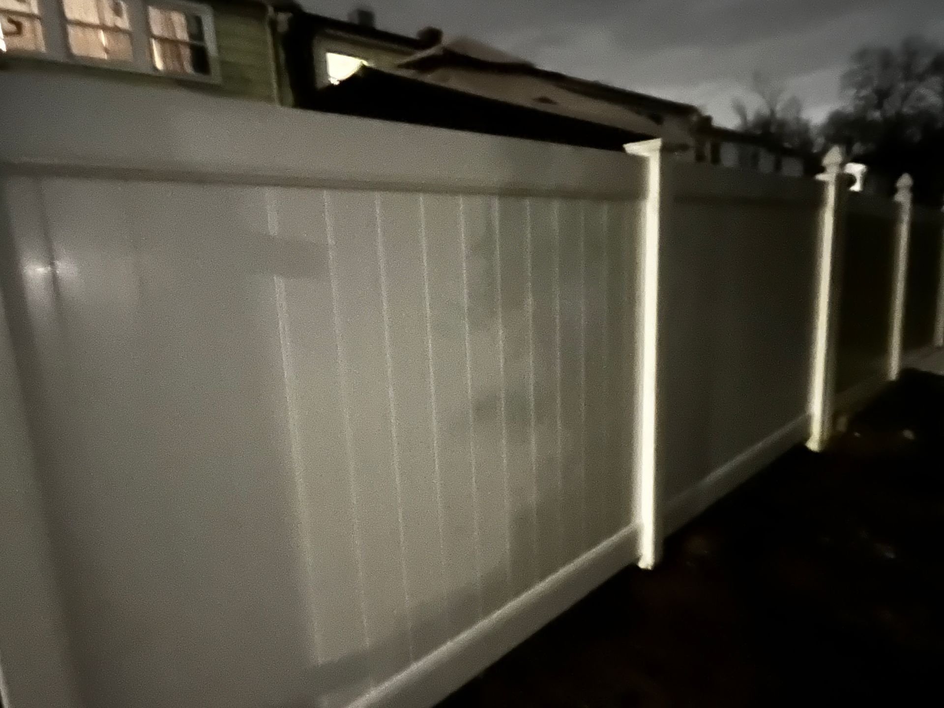 Nighttime white vinyl privacy fence side view in Burlington County NJ