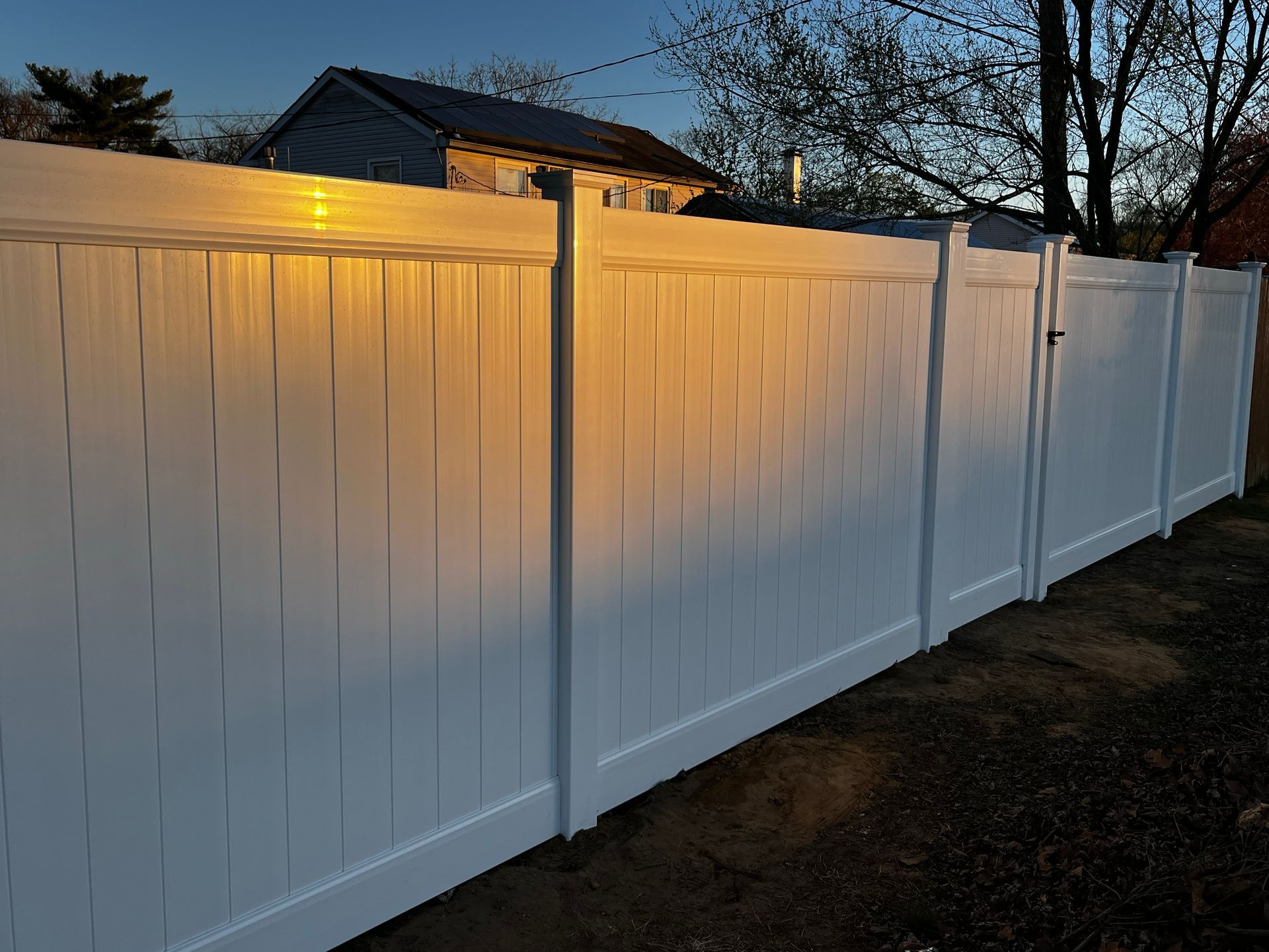 Finished white vinyl privacy fence at dusk in Burlington County NJ