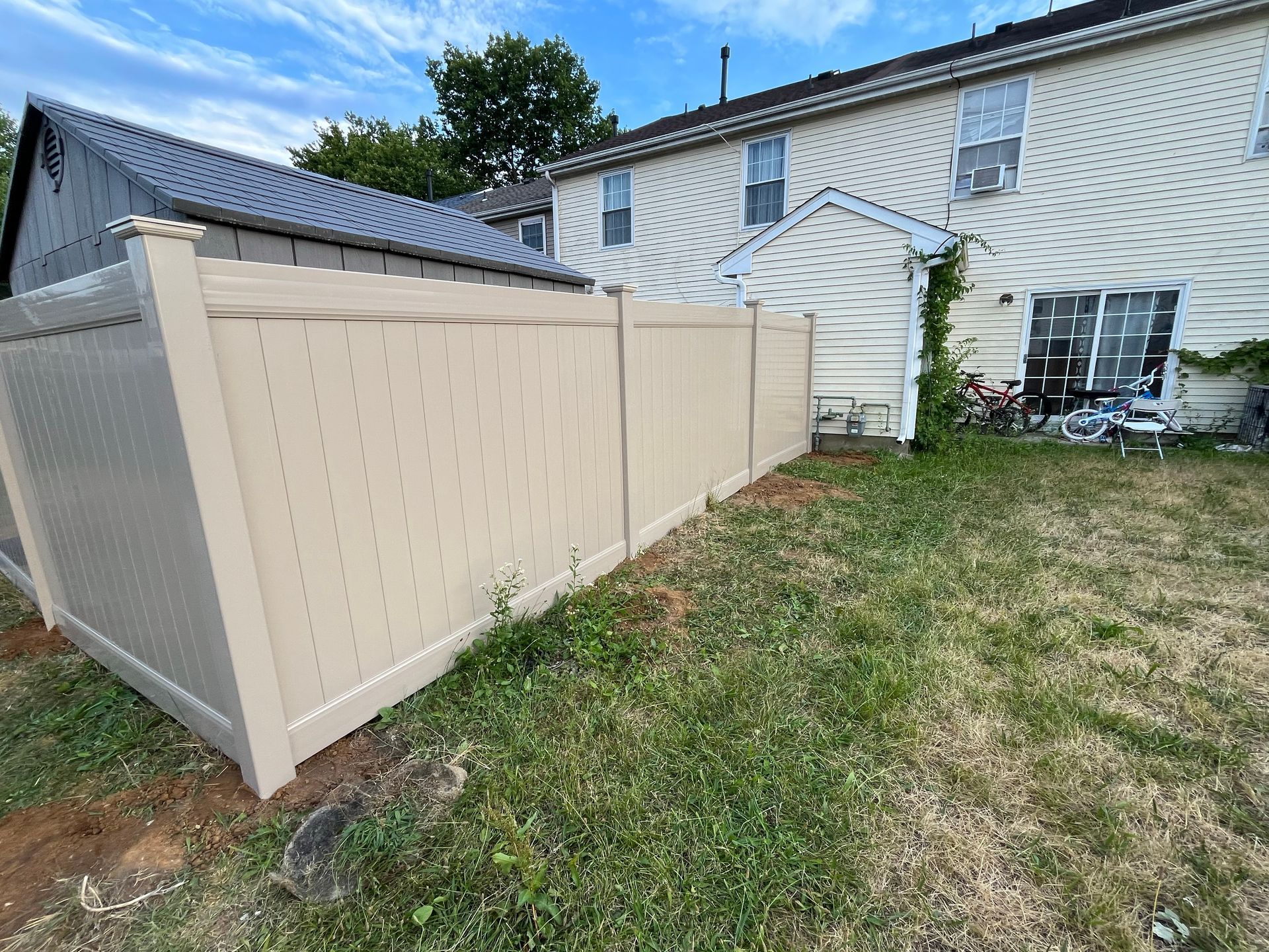 Backyard tan vinyl privacy fence installation in Burlington County NJ