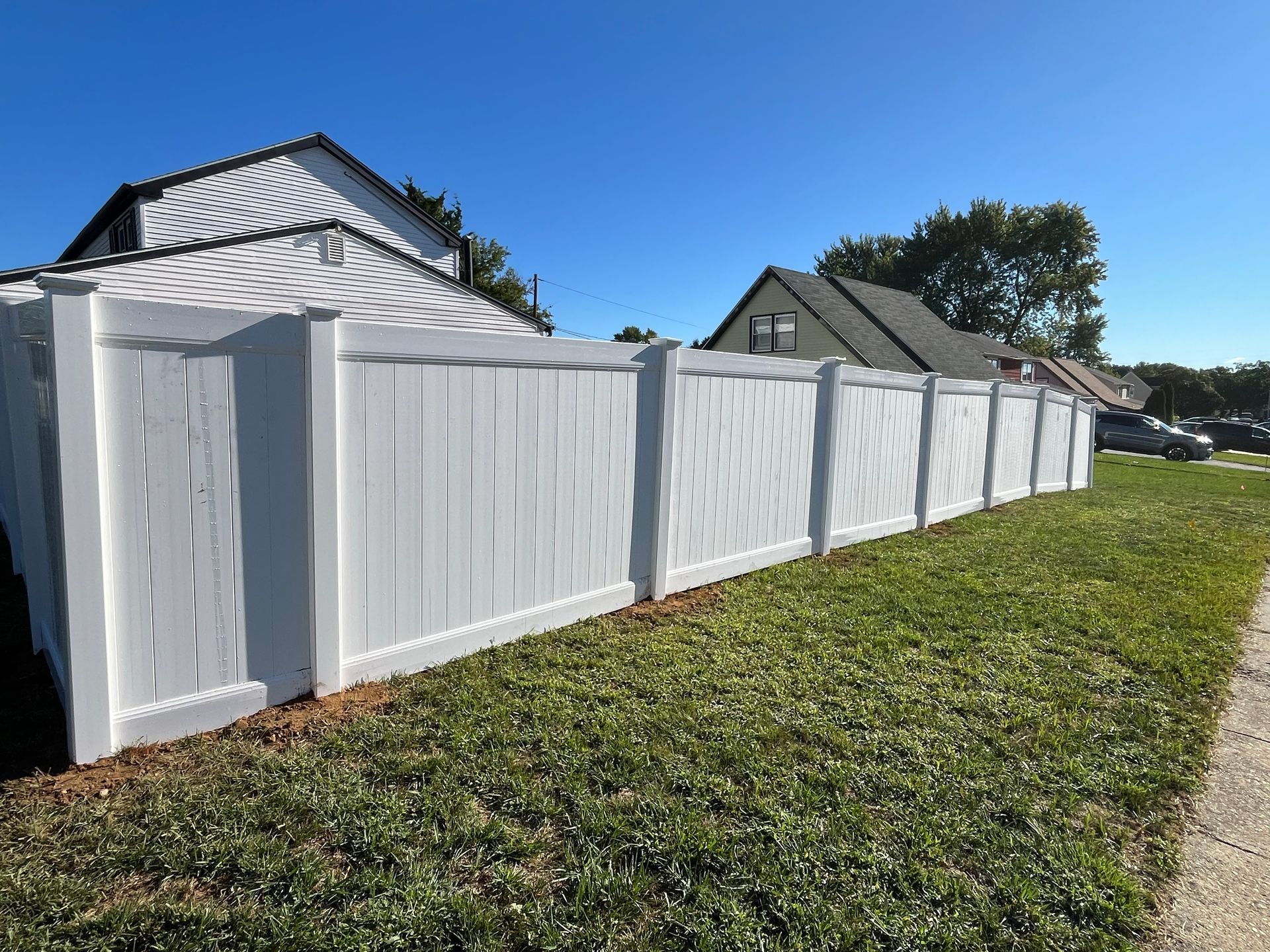 Long white vinyl privacy fence line beside home in Burlington County NJ