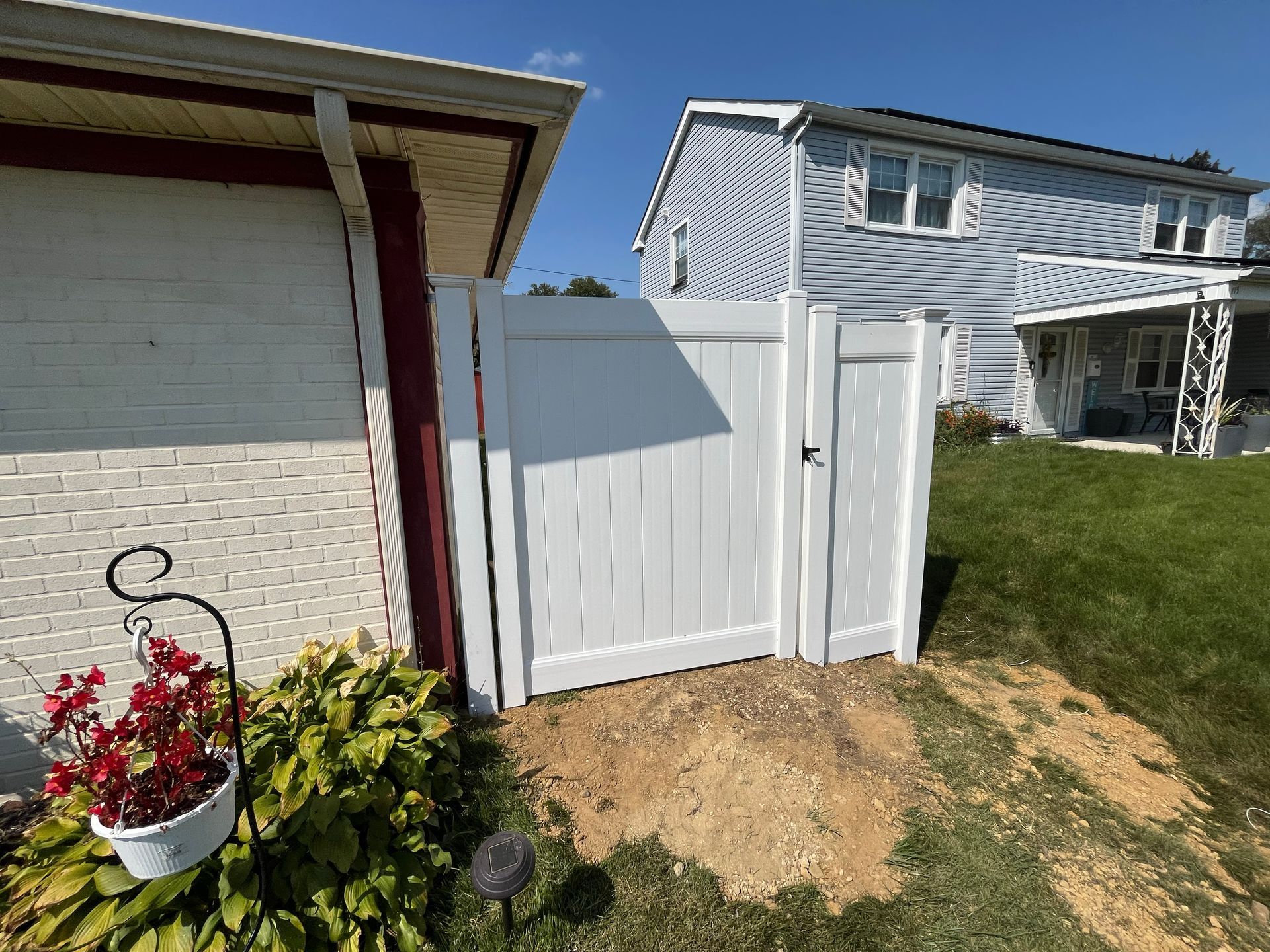 Single gate white vinyl fence beside home in Burlington County NJ