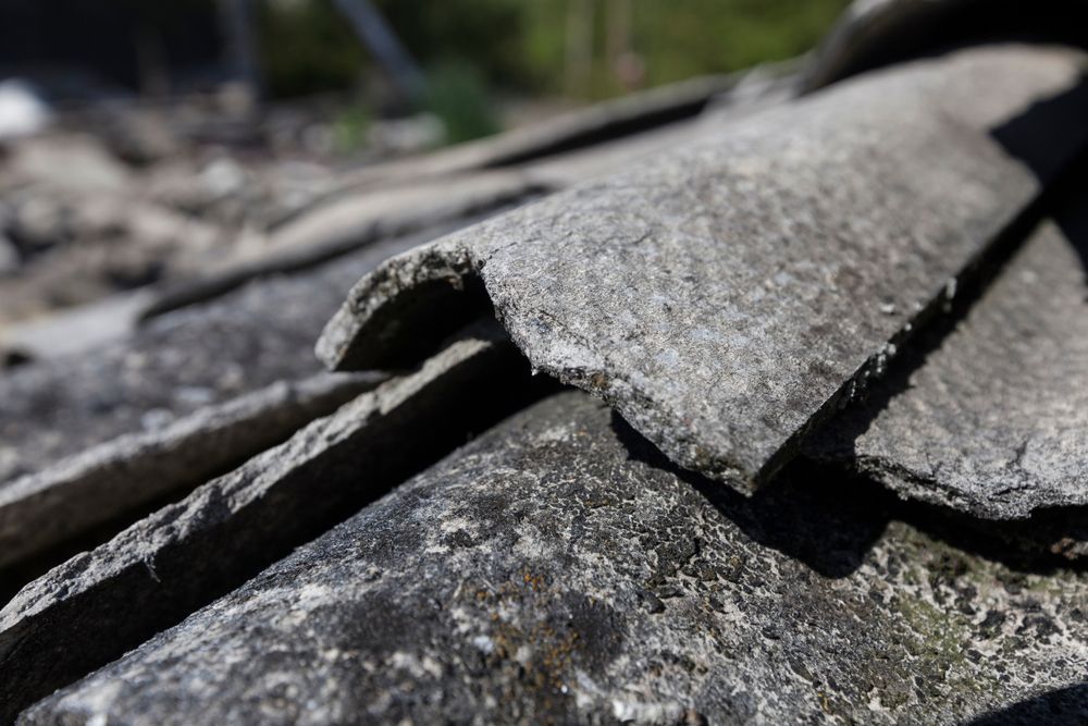 Close-up of Weathered, Gray Asbestos Roof Tiles, Curled Edges, Outdoors — Darren Smith Roofing In Glendale, NSW