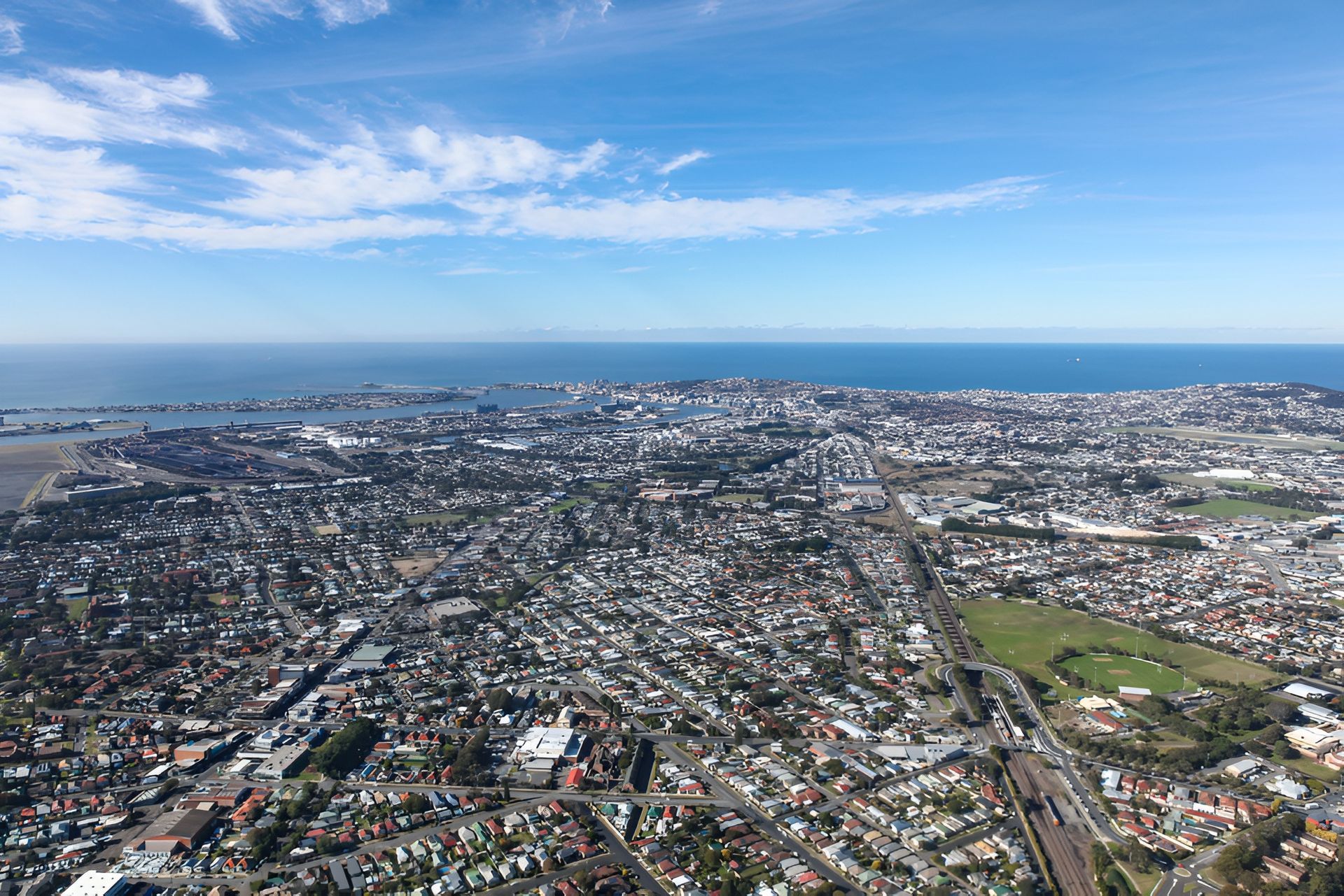Aerial View of a Densely Populated Coastal City With Houses — Darren Smith Roofing In Kotara, NSW