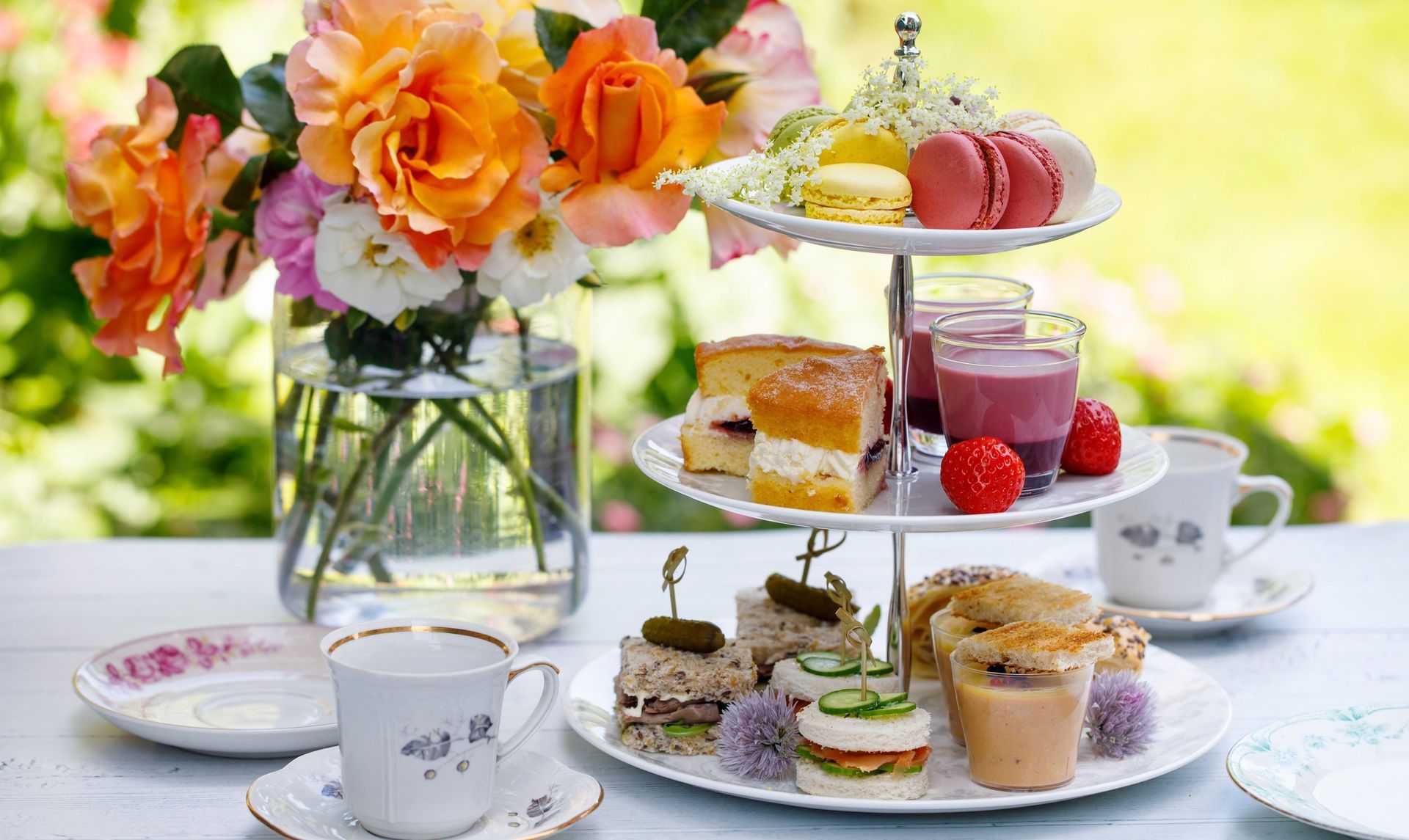Afternoon tea set with flowers and treats.