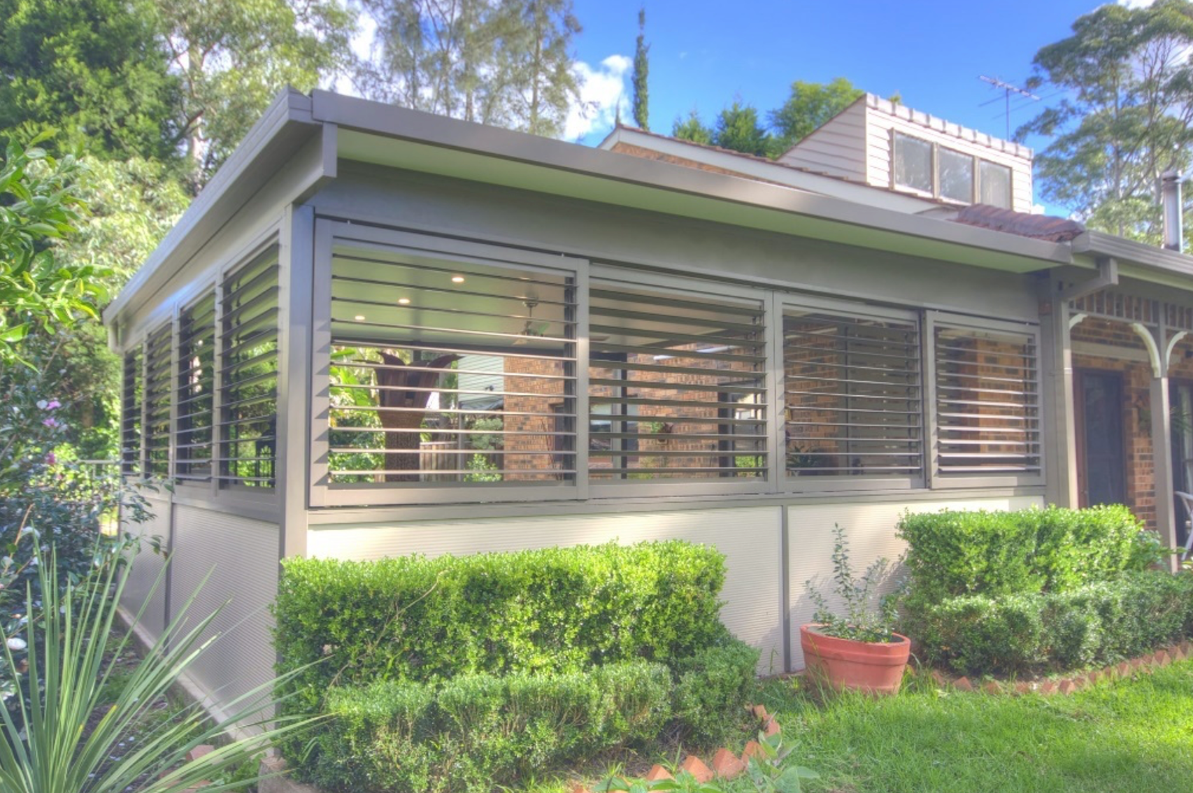 A house with a lot of windows and shutters on the side of it.