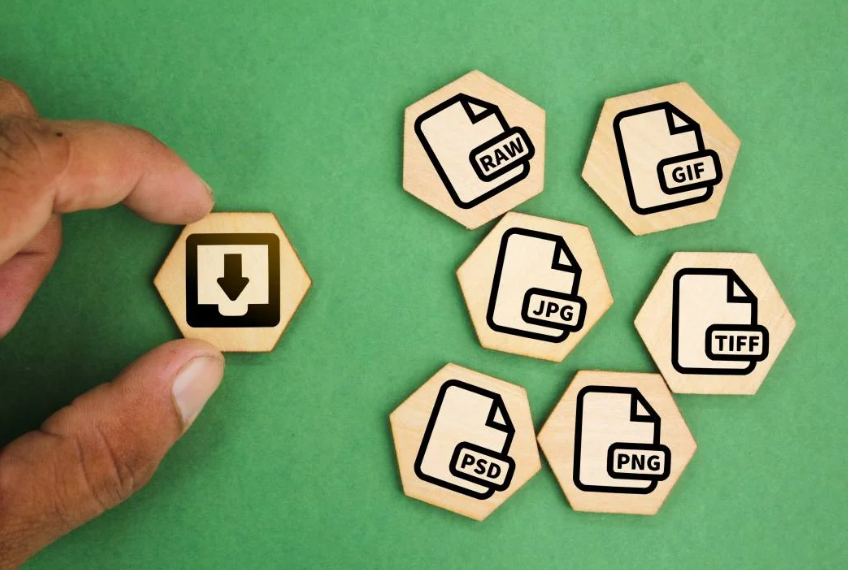 Una mano coloca un icono de descarga junto a iconos de formato de archivo sobre un fondo verde.