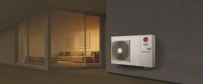 Eine weisse Wärmepumpe häng an einer grauen wand in einem gemütlichen Raum