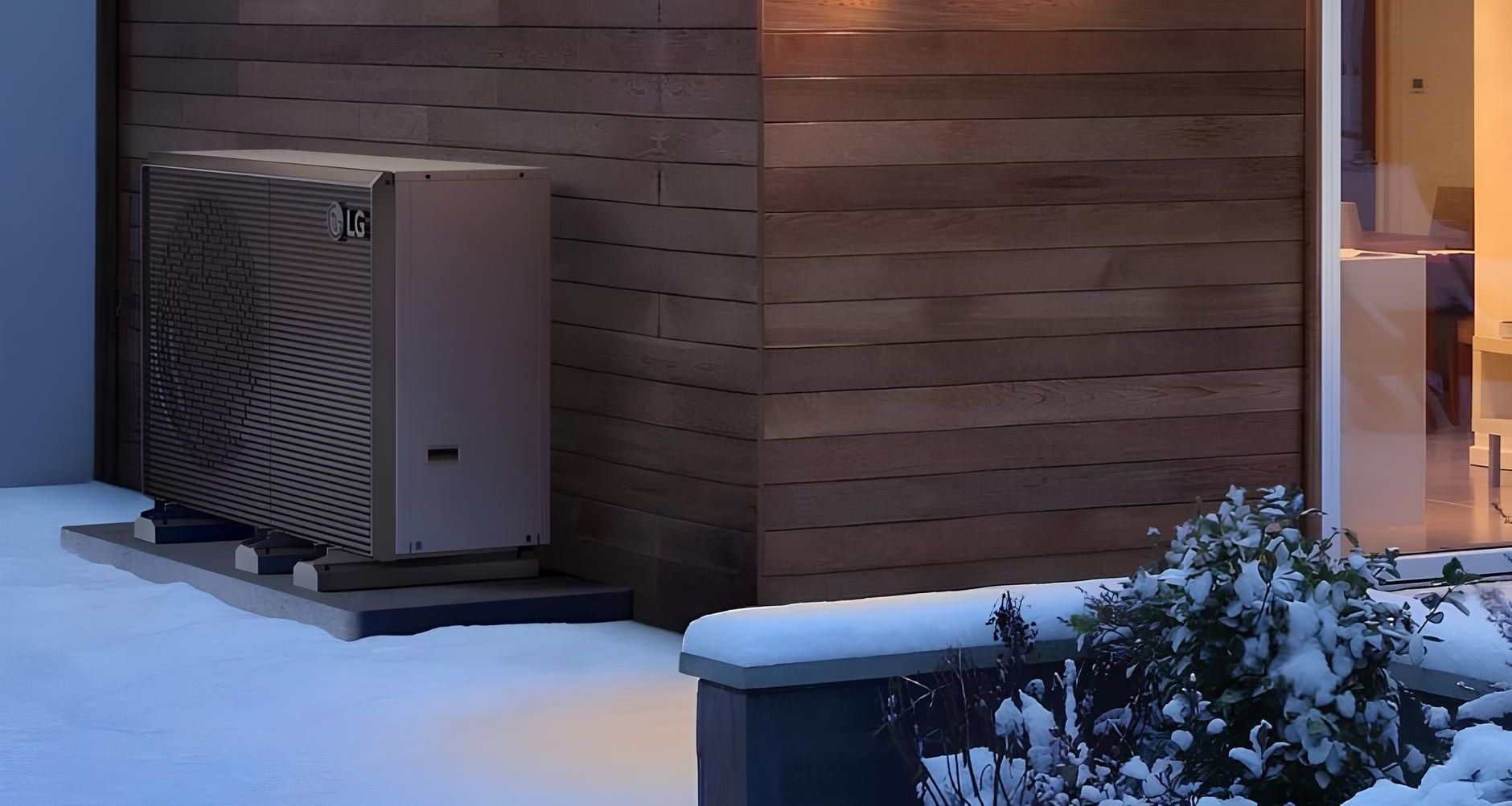 Graue Wärmepumpe steht hinter einer Ecke an einer Holzwand
