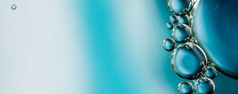 Bild von mehreren Tropfen vor einem hellblauen Hintergrund