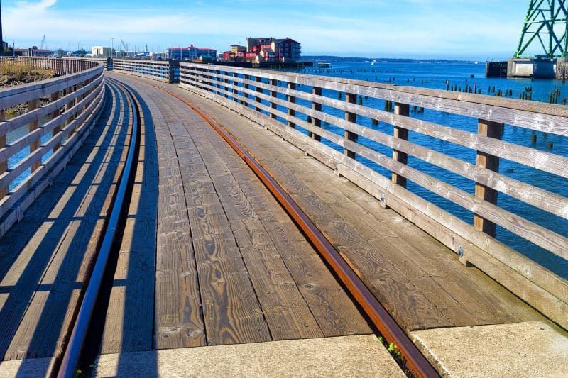 A wooden bridge over a body of water with a railing
