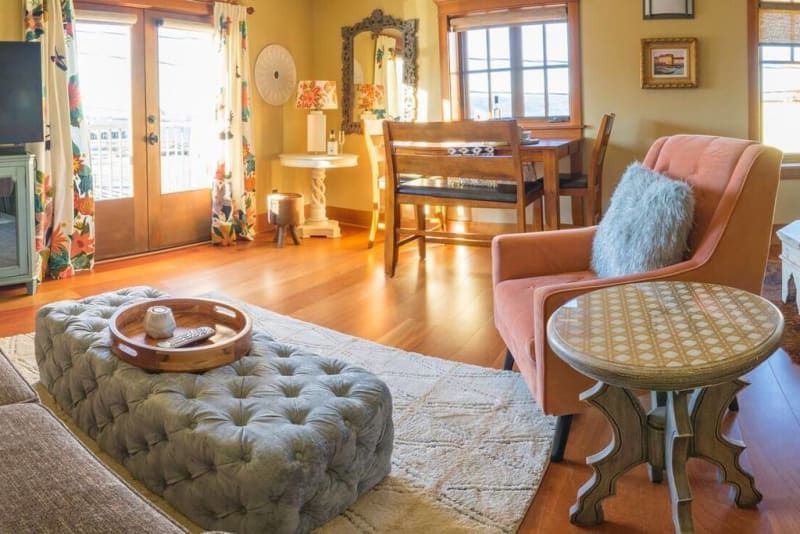 A living room with a couch , chair , table and ottoman.