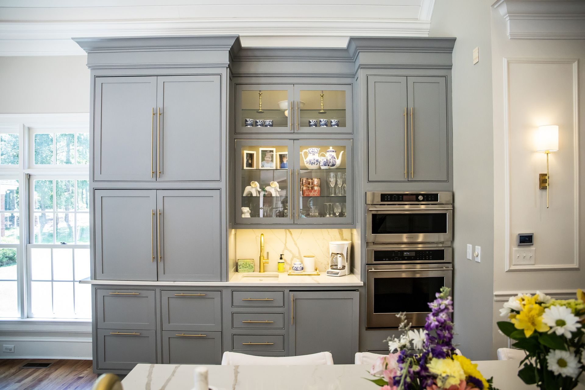 A kitchen with gray cabinets and stainless steel appliances.