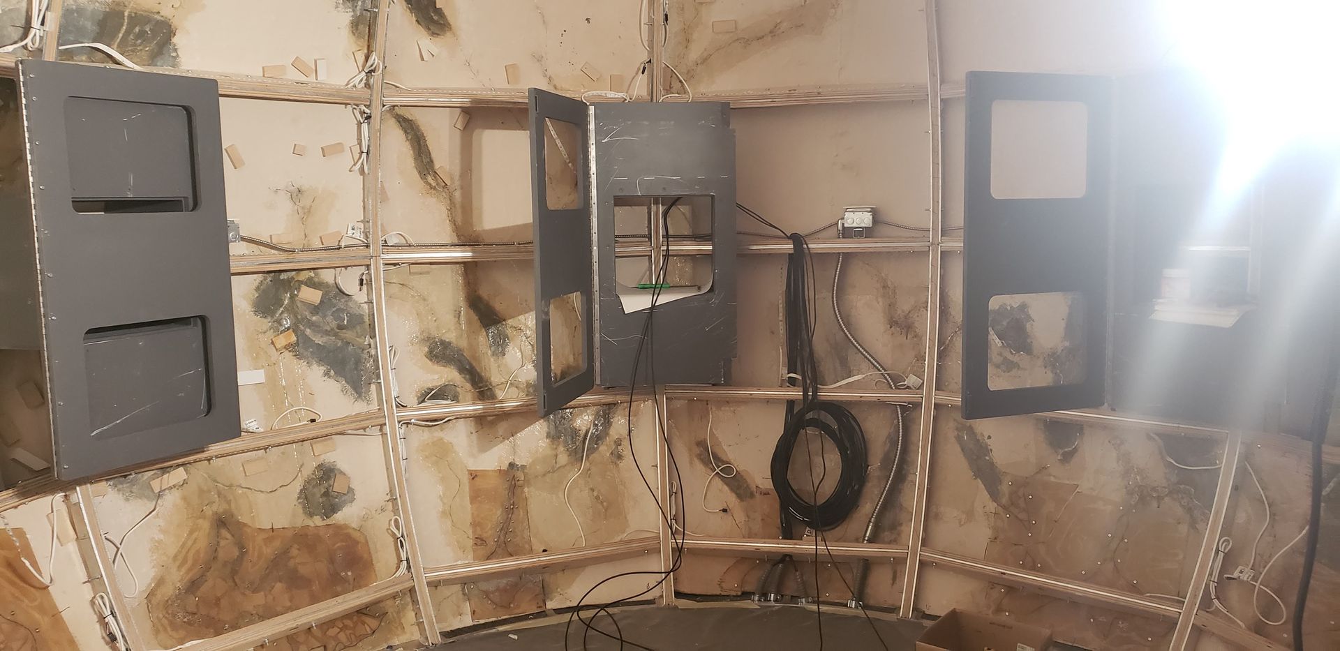 A room with a lot of boxes on the wall and a light shining through them.