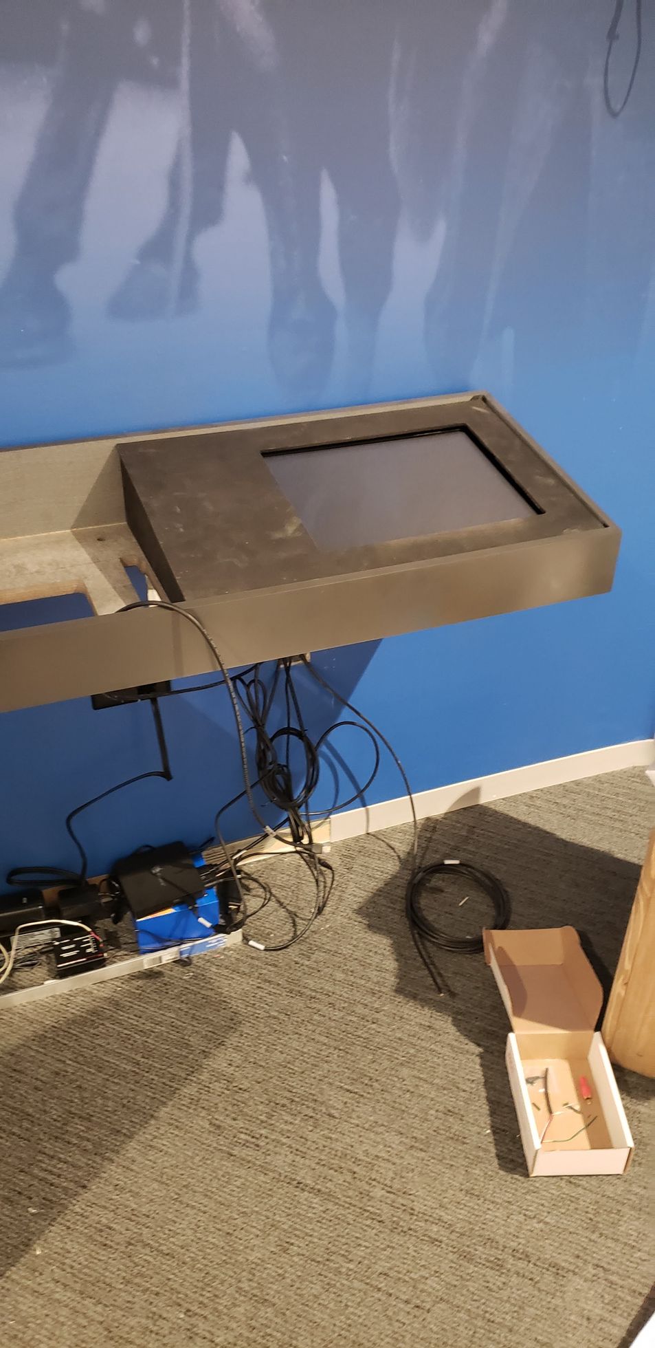 A computer monitor is mounted on a wall in a room.