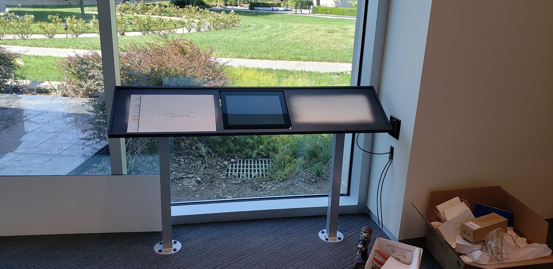 A desk is sitting in front of a window in a room.
