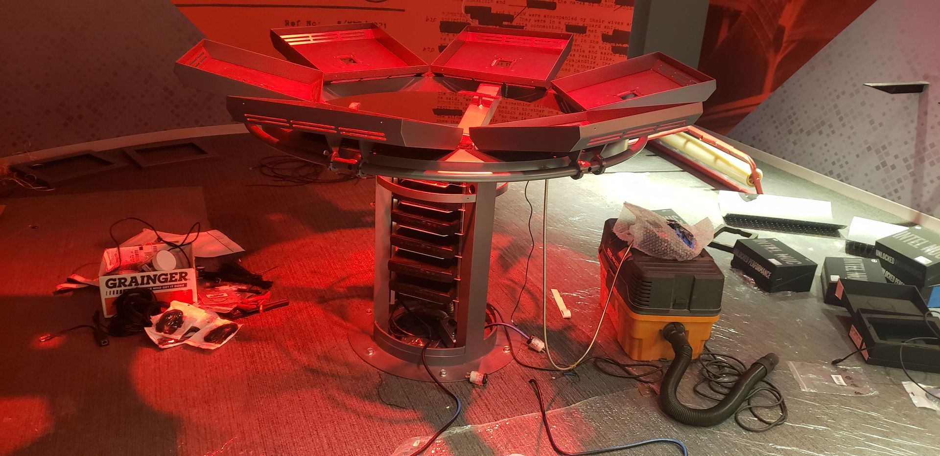 A vacuum cleaner is sitting on the floor next to a table.