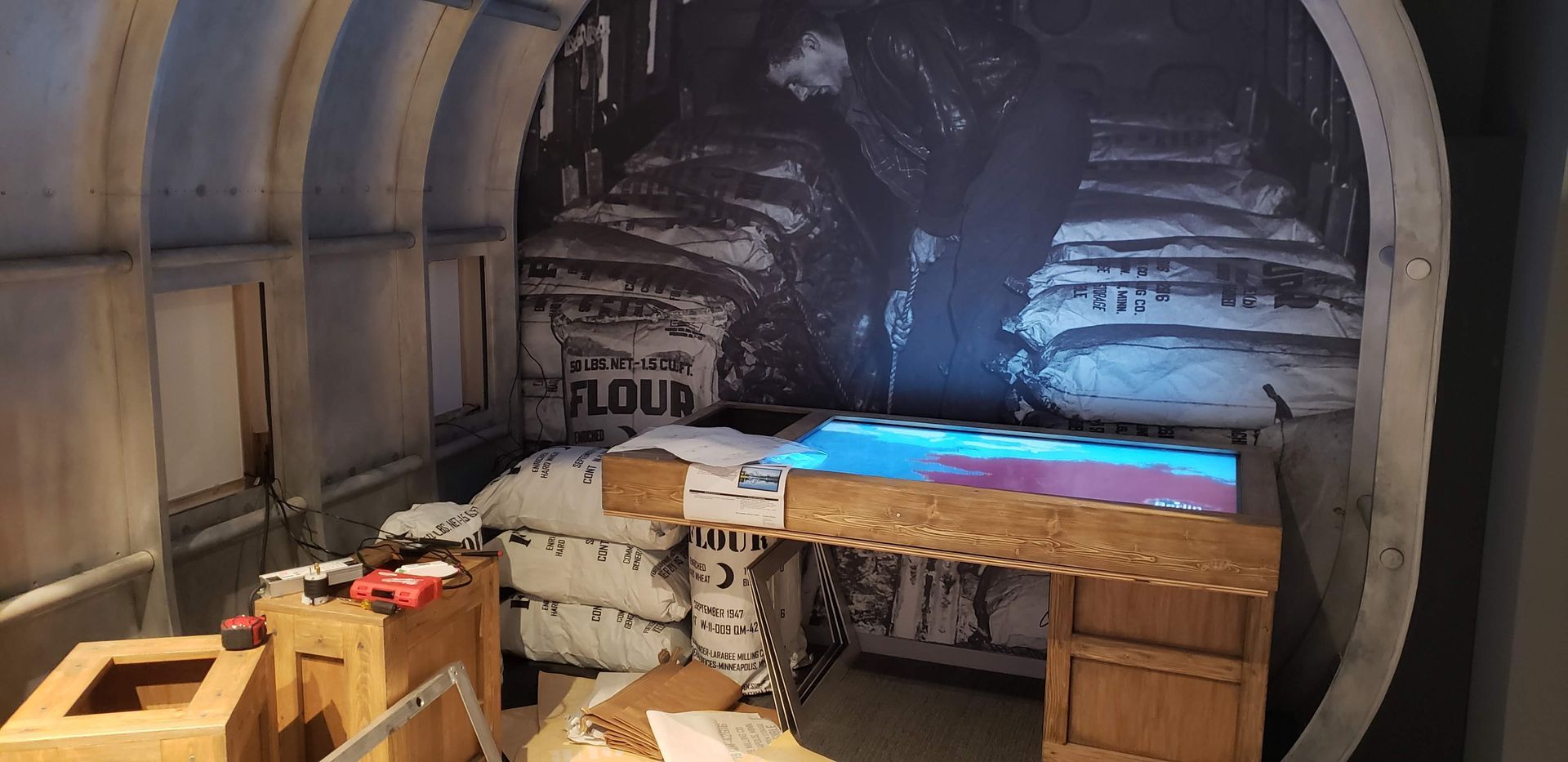 A room with a desk and a painting on the wall.