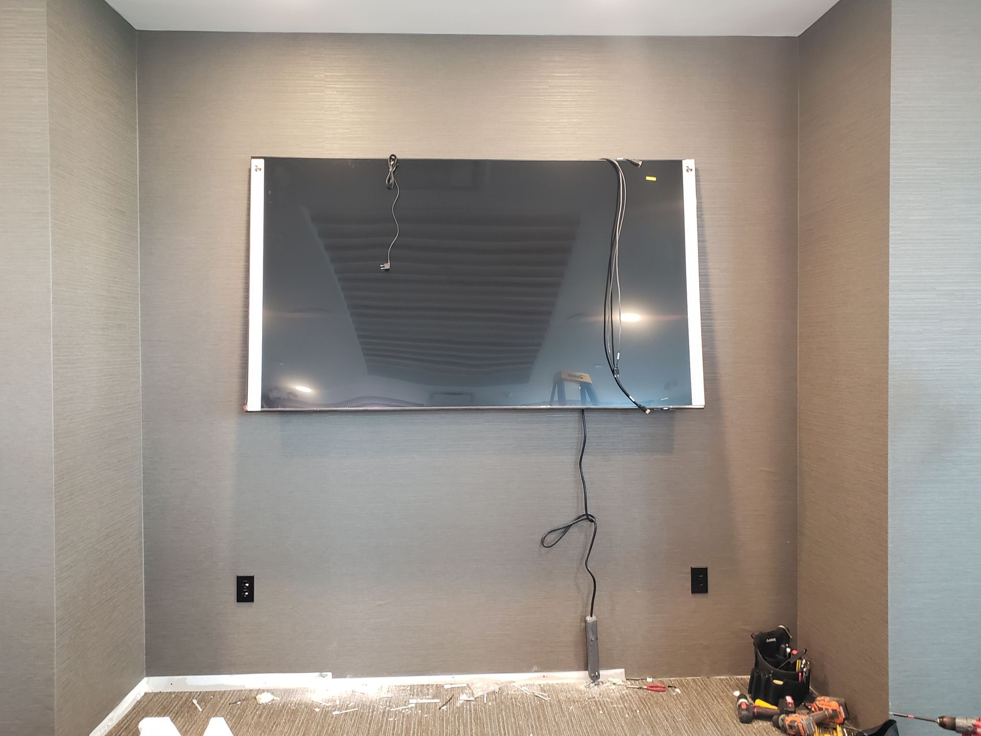 A large flat screen tv is hanging on a wall in a room.